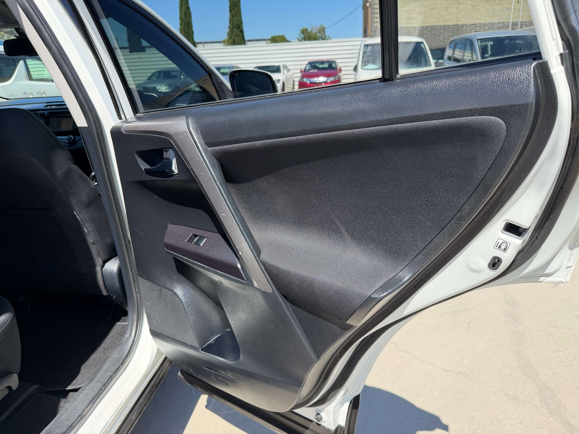 Interior view of the driver's side door panel of a 2016 Toyota RAV4, showcasing features and design.