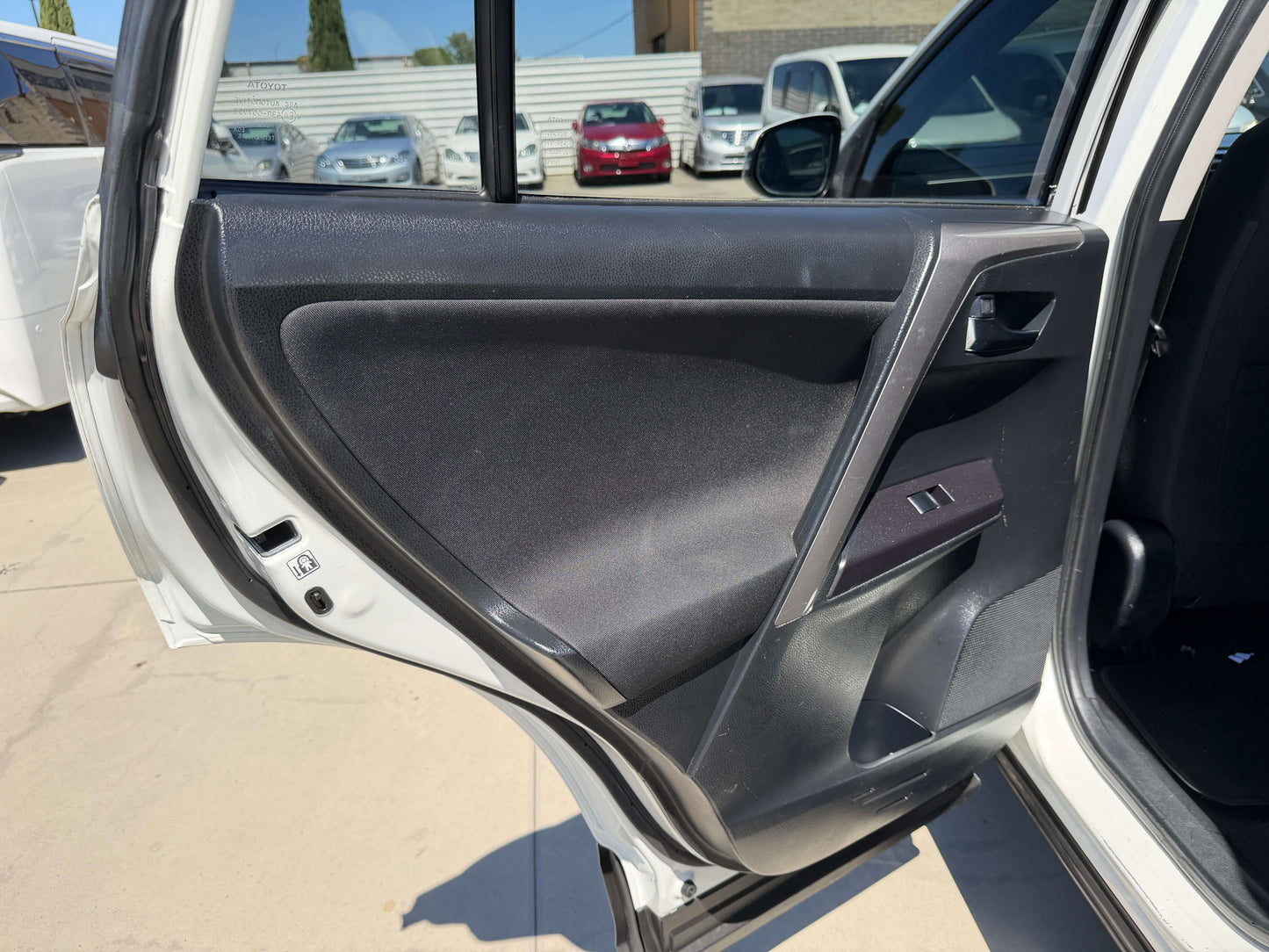 Interior view of the 2016 Toyota RAV4 driver's side door, showing panel and controls.