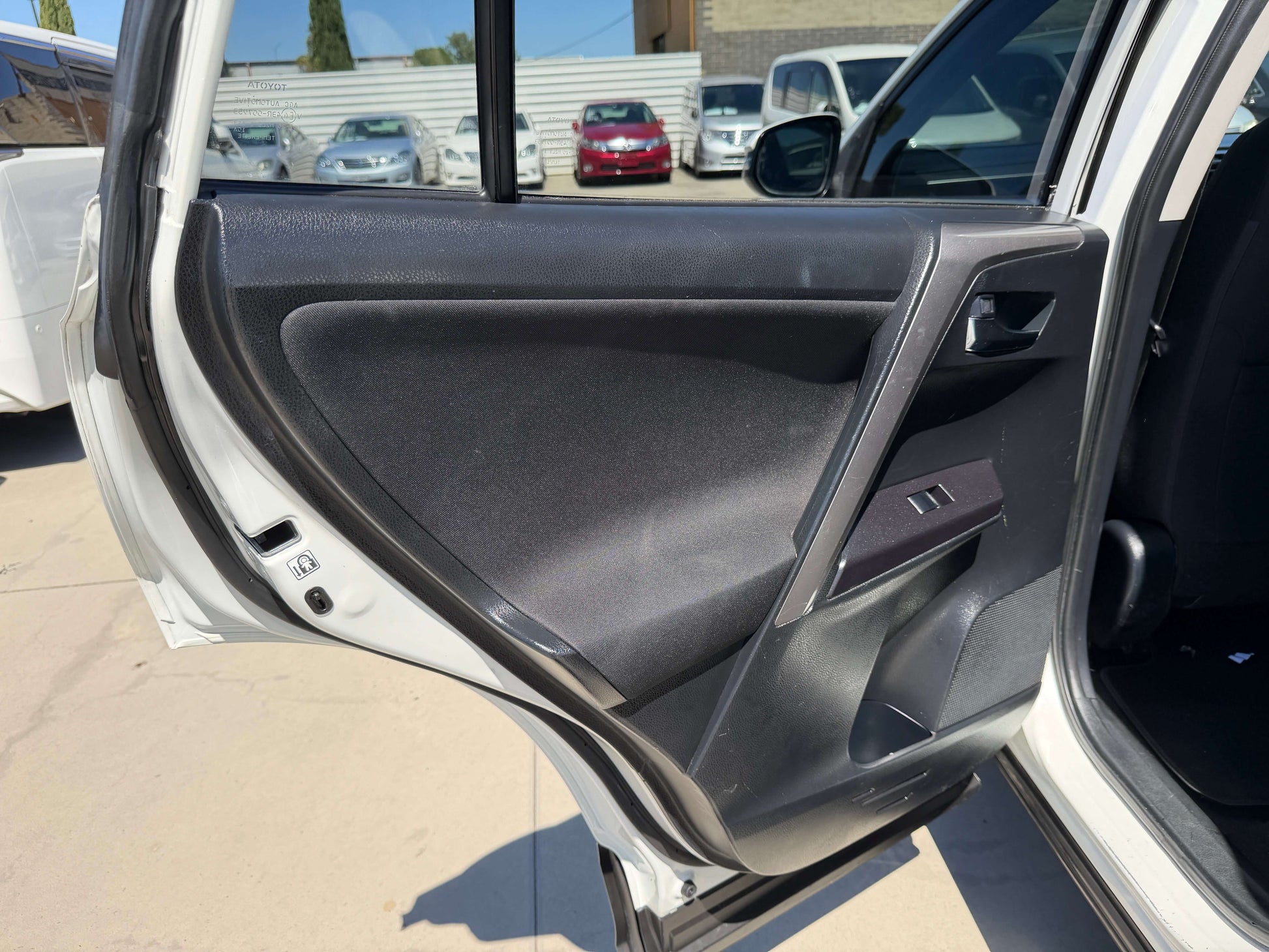 Interior view of the 2016 Toyota RAV4 driver's side door, showing panel and controls.