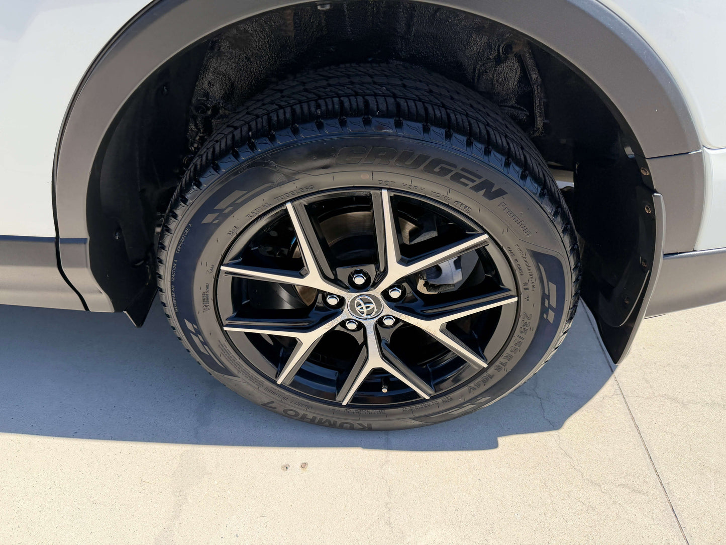 Close-up view of the black alloy wheel and tire of a 2016 Toyota RAV4 showcasing stylish design and performance.