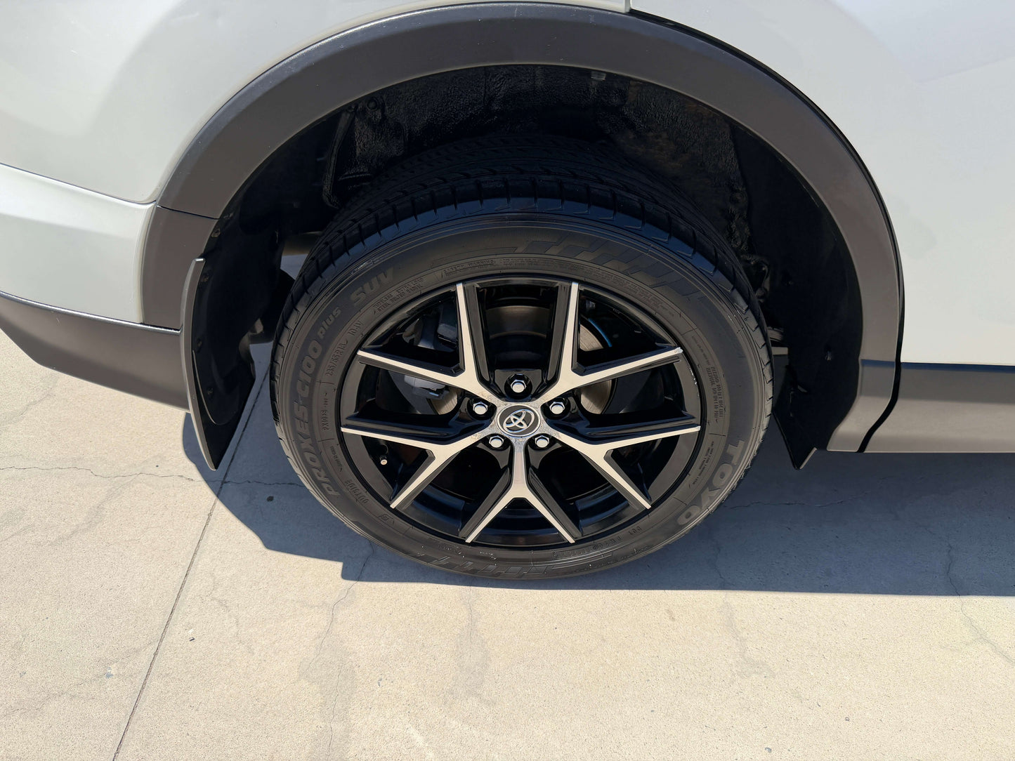 Close-up of a stylish black alloy wheel on a 2016 Toyota RAV4, showcasing the modern tire design and rim details.