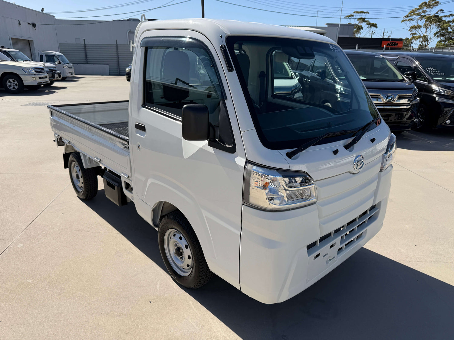 2021 Daihatsu Hijet Truck 660 Standard SA IIIt 3-Way 4WD in white color, showcasing its compact design and flatbed.