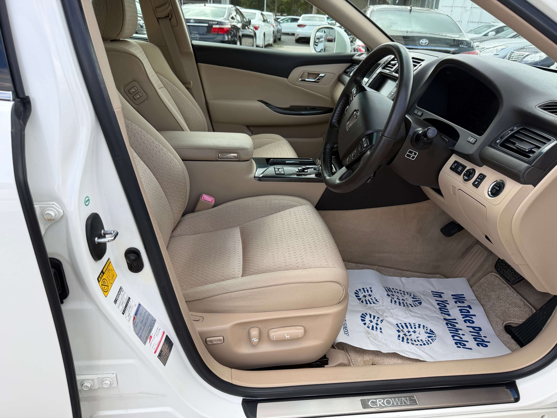 Interior view of 2009 Toyota Crown V6 3.5L Hybrid G-Edition Luxury Sedan showcasing tan upholstery and dashboard.
