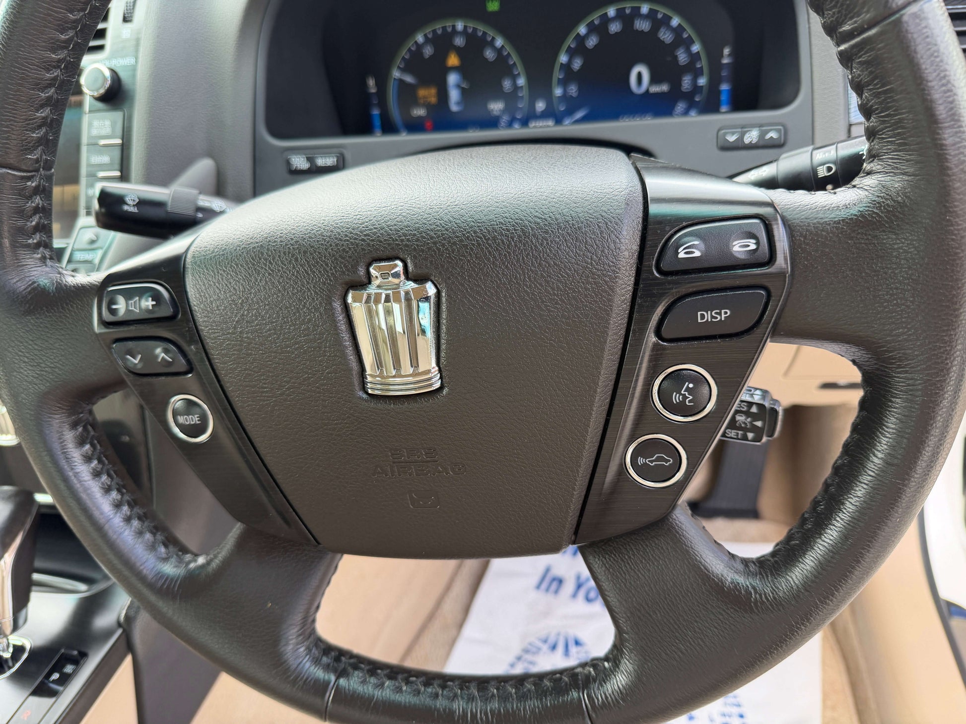 2009 Toyota Crown V6 3.5L Hybrid steering wheel with controls and dashboard visible.