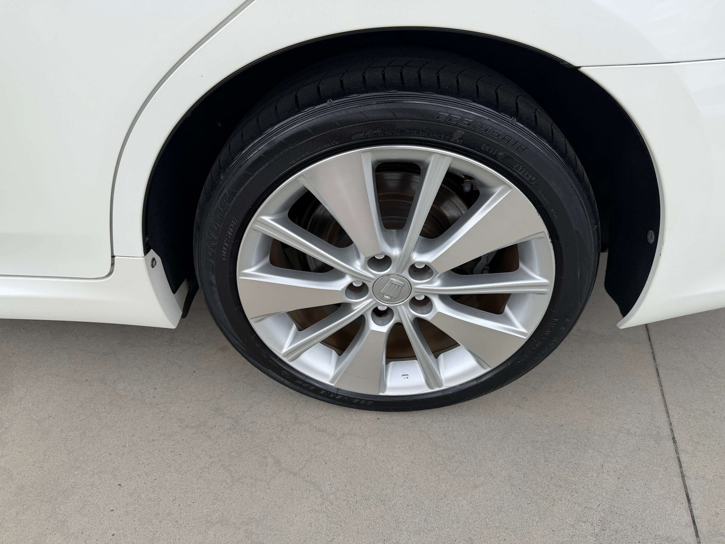 Close-up of the wheel of a 2009 Toyota Crown V6 3.5L Hybrid G-Edition Luxury Sedan showcasing sleek rim design.