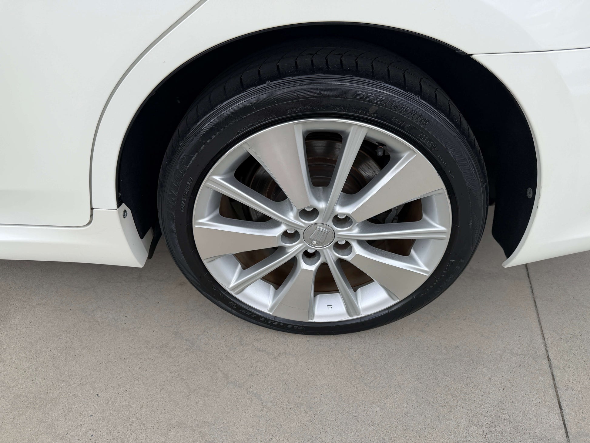 Close-up of the wheel of a 2009 Toyota Crown V6 3.5L Hybrid G-Edition Luxury Sedan showcasing sleek rim design.