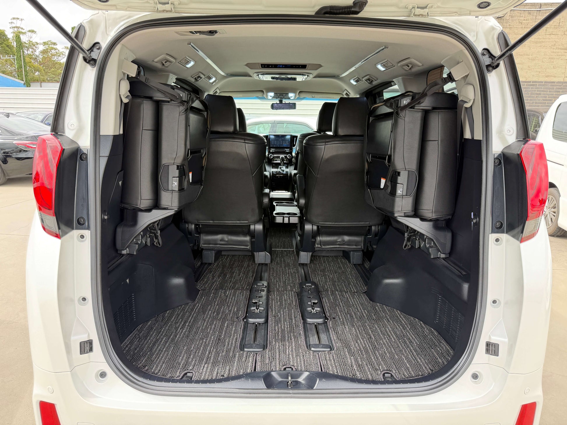 Interior view of the 2016 Toyota Alphard 2.5L showing spacious seating arrangement with black leather seats.