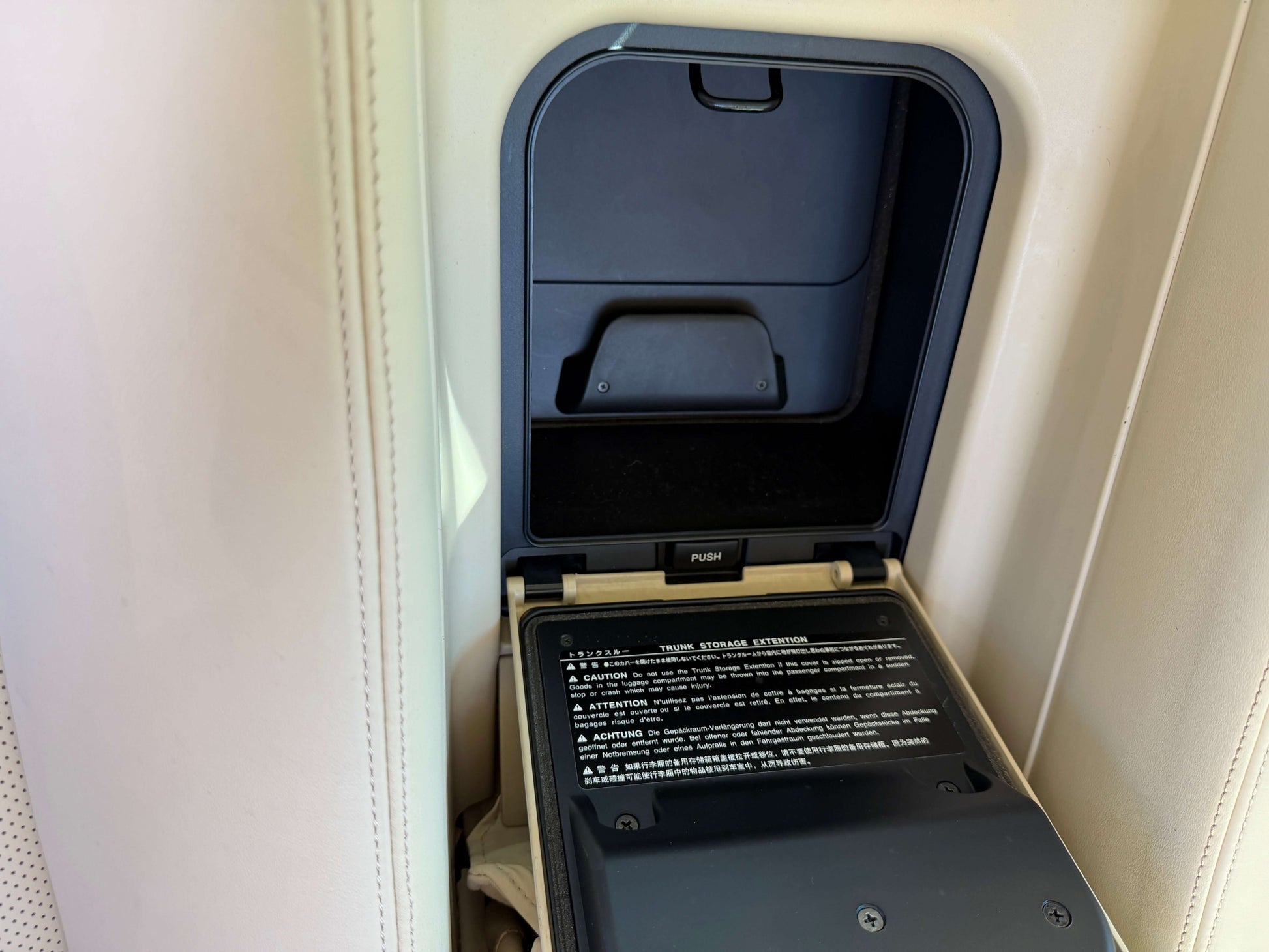 Interior compartment of a 2010 Lexus LS460 AWD V8 4.6L luxury sedan showing storage area with instructions.