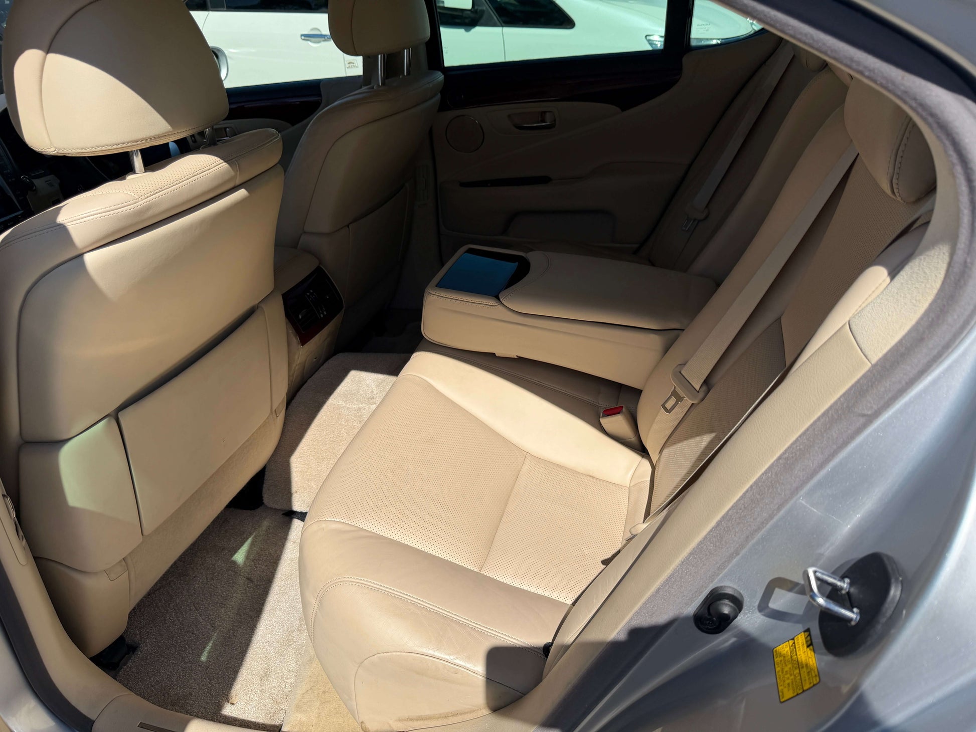 2010 Lexus LS460 AWD V8 4.6L luxury sedan rear interior with beige leather seats and armrest.