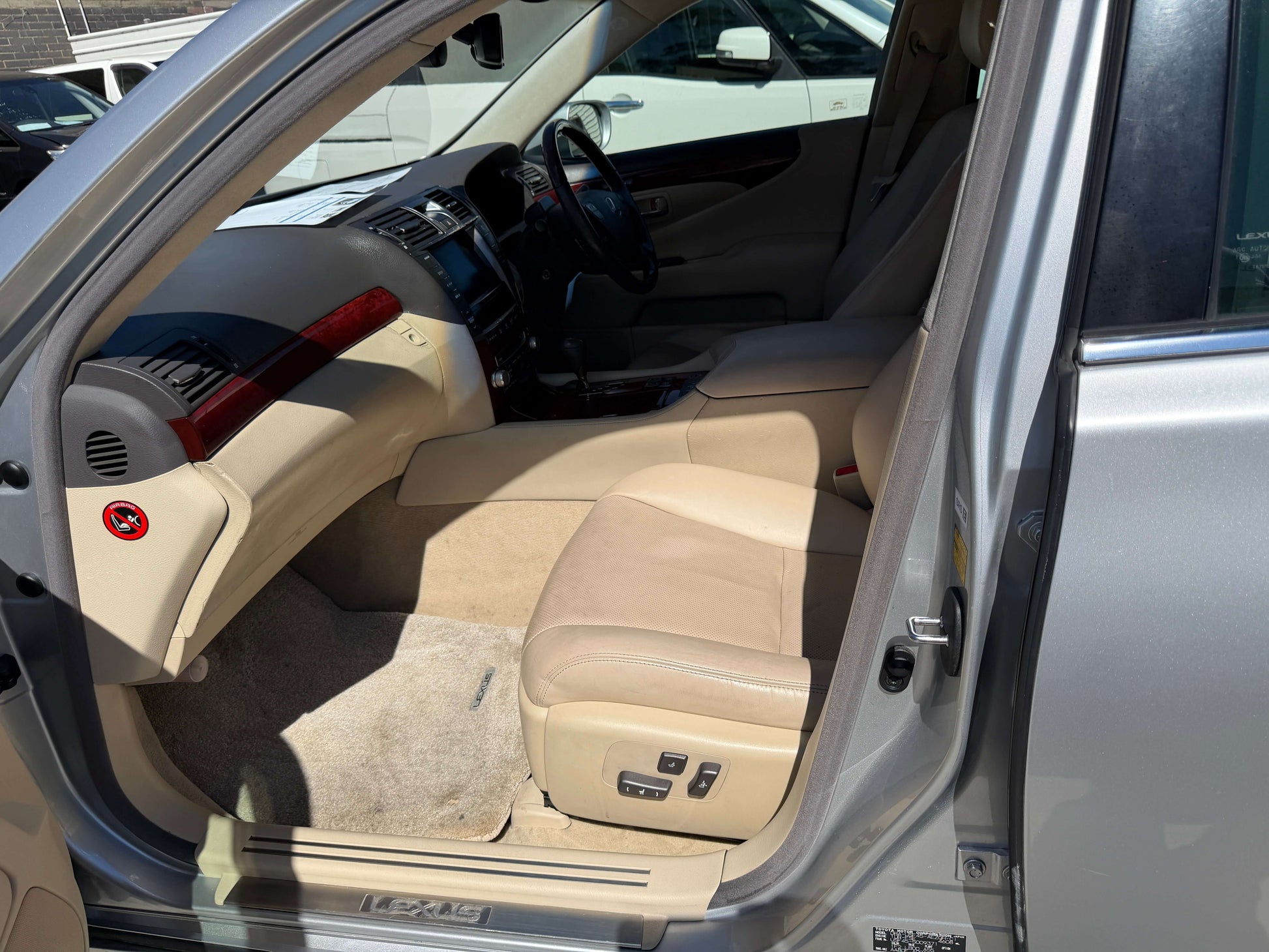 Interior view of a 2010 Lexus LS460 AWD V8 4.6L showing premium beige leather seats and dashboard details.