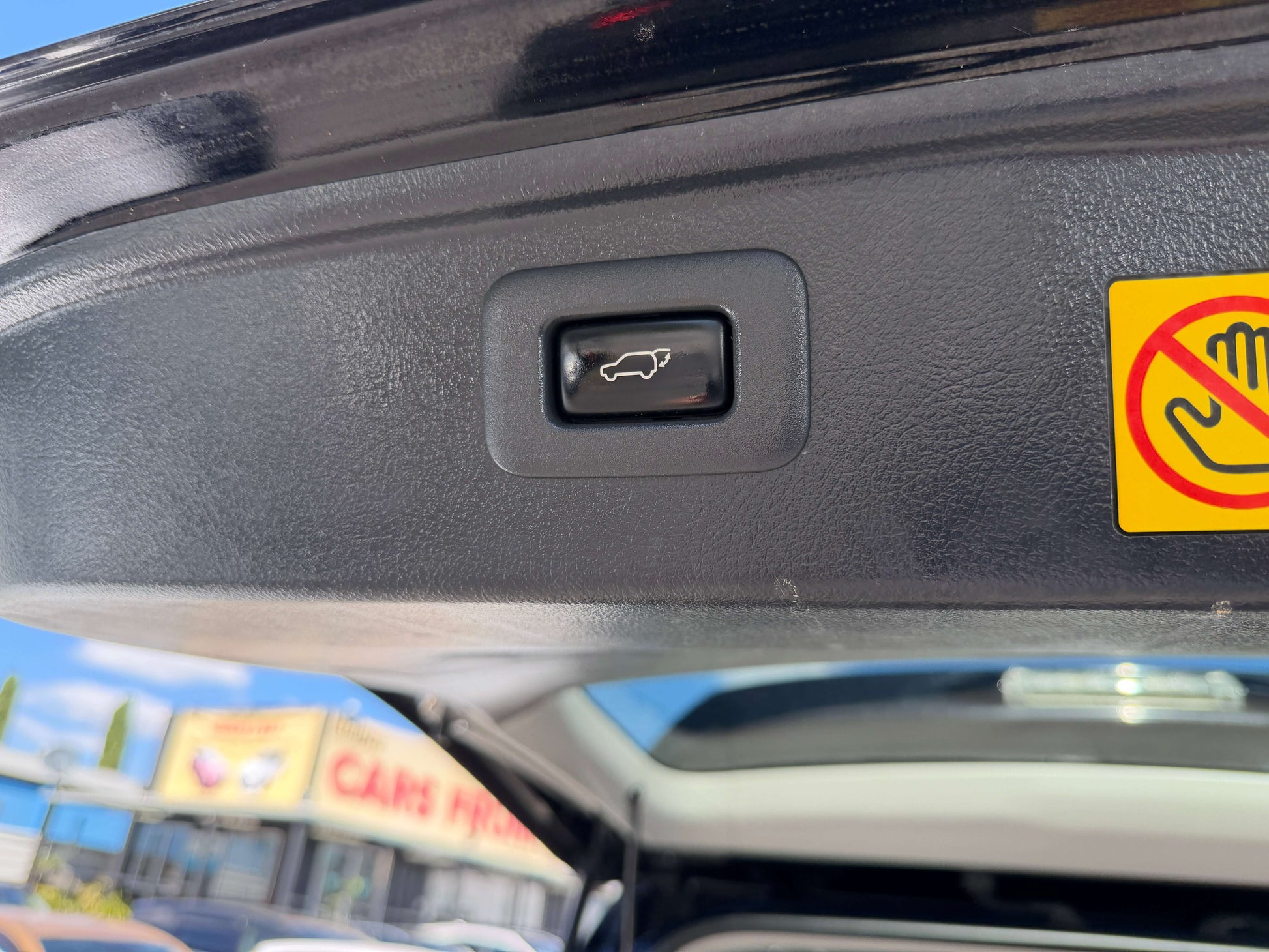 Close-up of the trunk release button in a 2013 Toyota Vellfire 2.4L Z Golden Eyes Edition.
