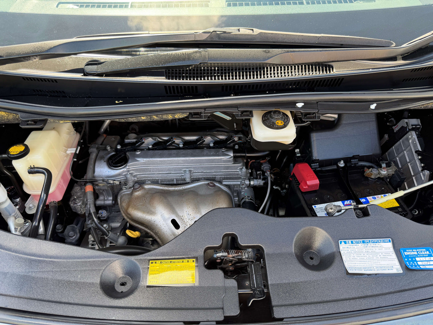 2013 Toyota Vellfire 2.4L engine compartment with components visible under the hood, showcasing vehicle maintenance area.