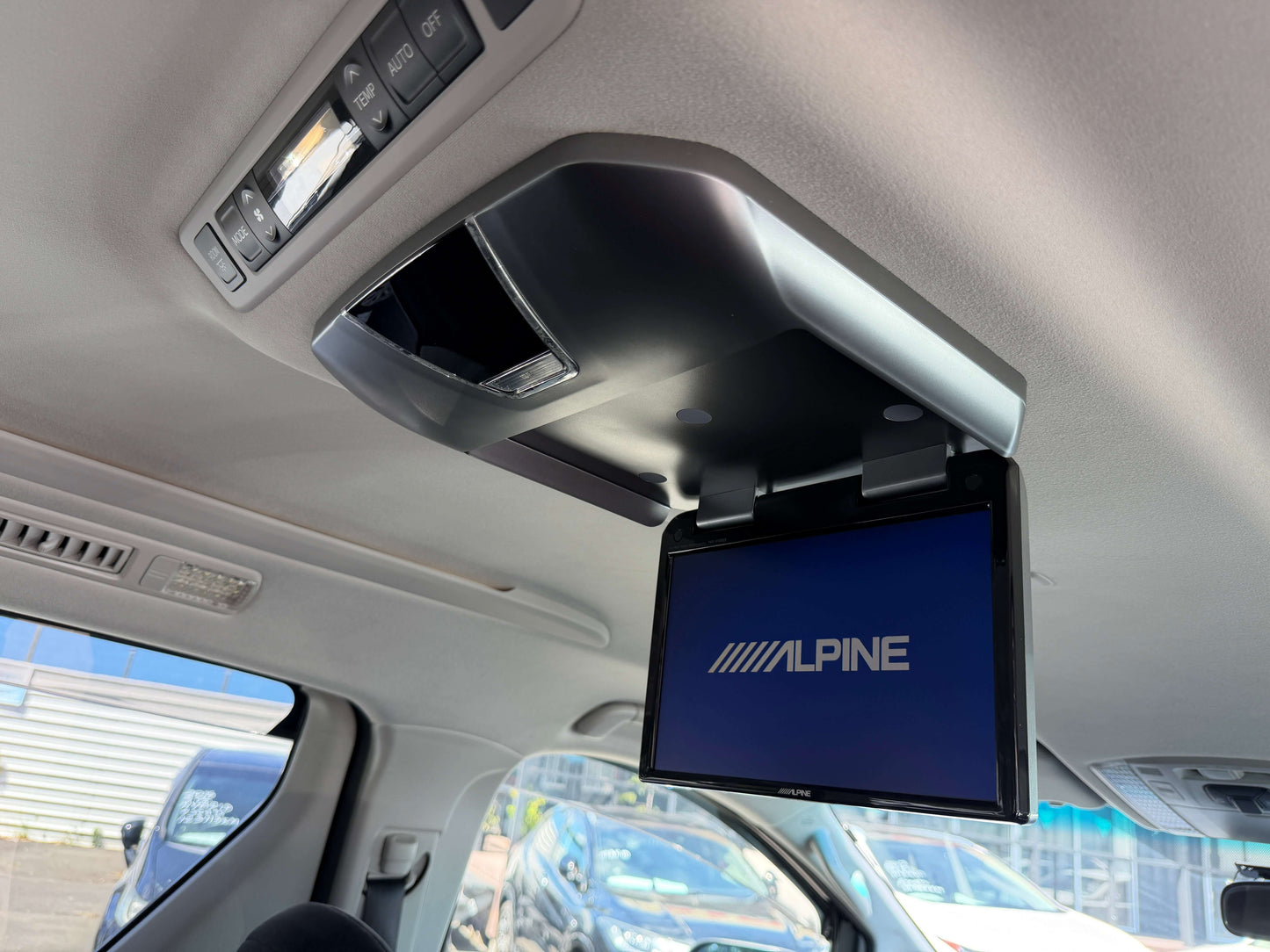 2009 Toyota Vellfire 2.4L Interior view showing Alpine overhead screen and lighting in a vehicle, designed for passenger entertainment.