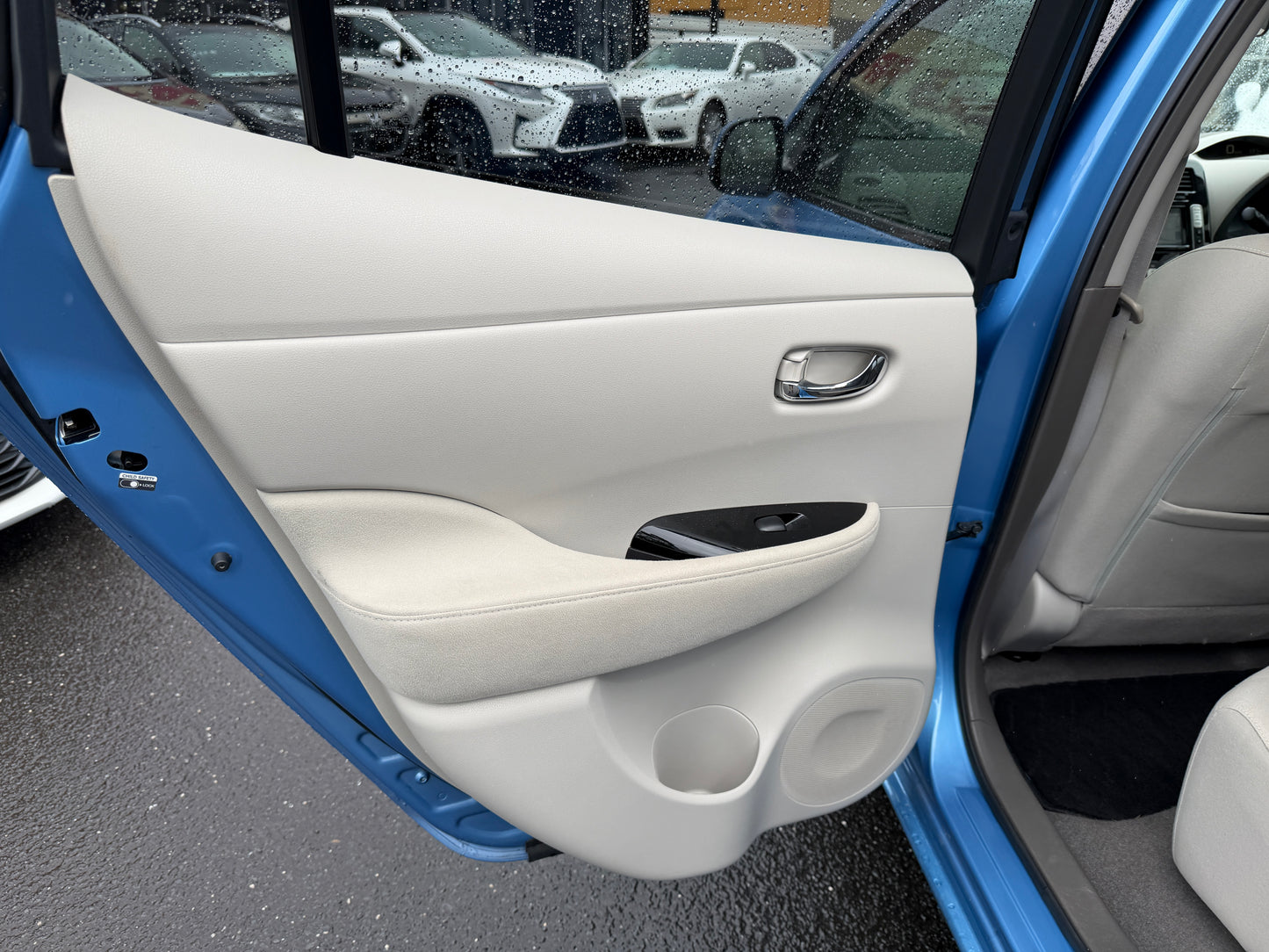 Interior door panel of a 2015 Nissan Leaf 24kW G-Edition Full Electric showing modern design and features.
