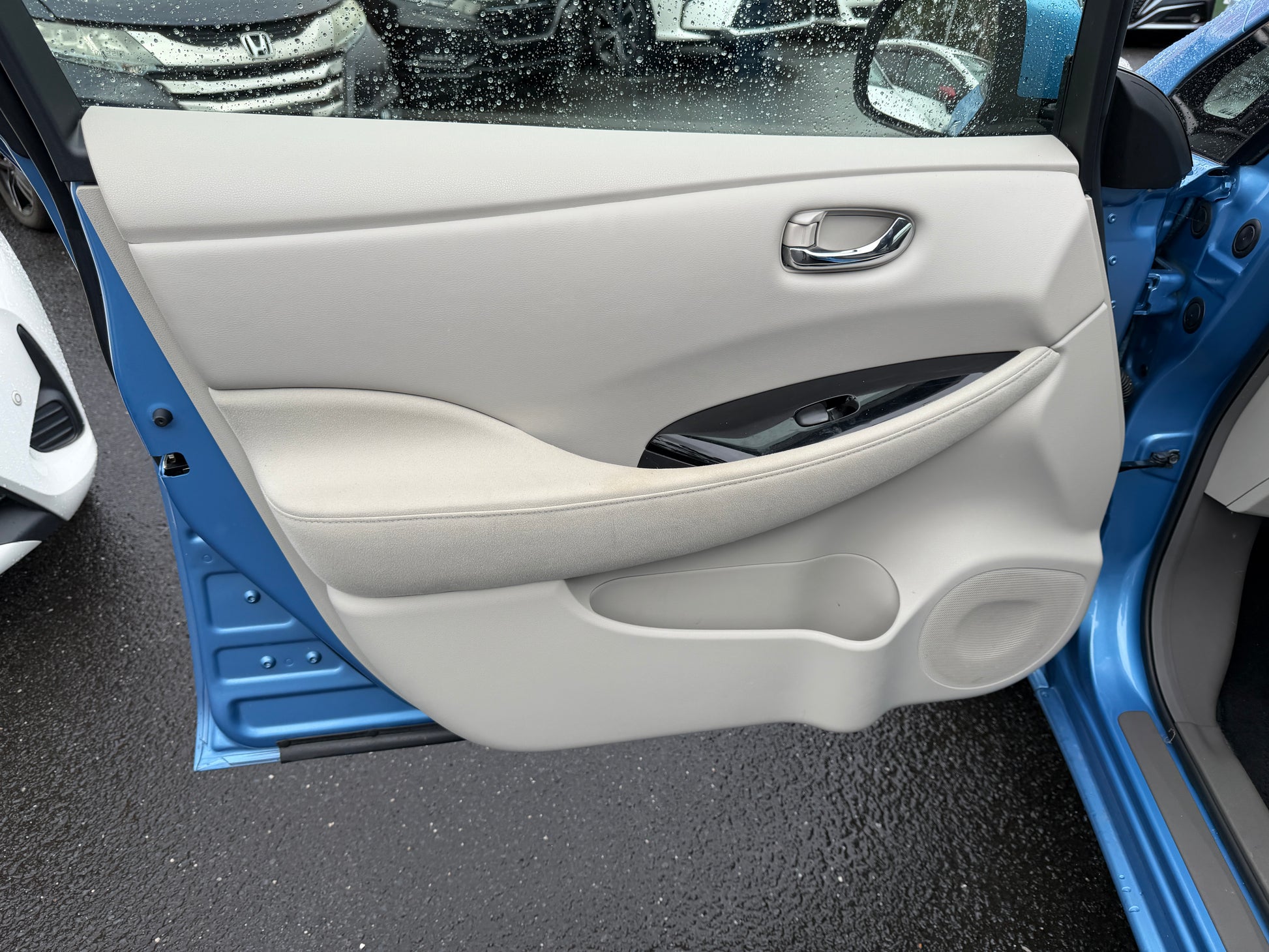 Interior door panel of a 2015 Nissan Leaf 24kW G-Edition Full Electric showcasing modern design and comfort features.