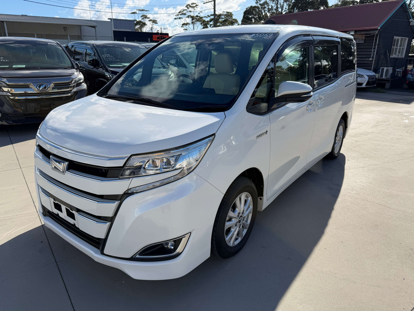 2017 Toyota Noah 1.8L Hybrid G Premium Edition 7 seater parked in showroom with clear sky.