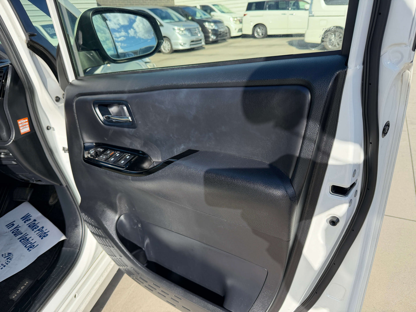 Interior view of the 2017 Toyota Noah 1.8L Hybrid door with controls and spacious design.