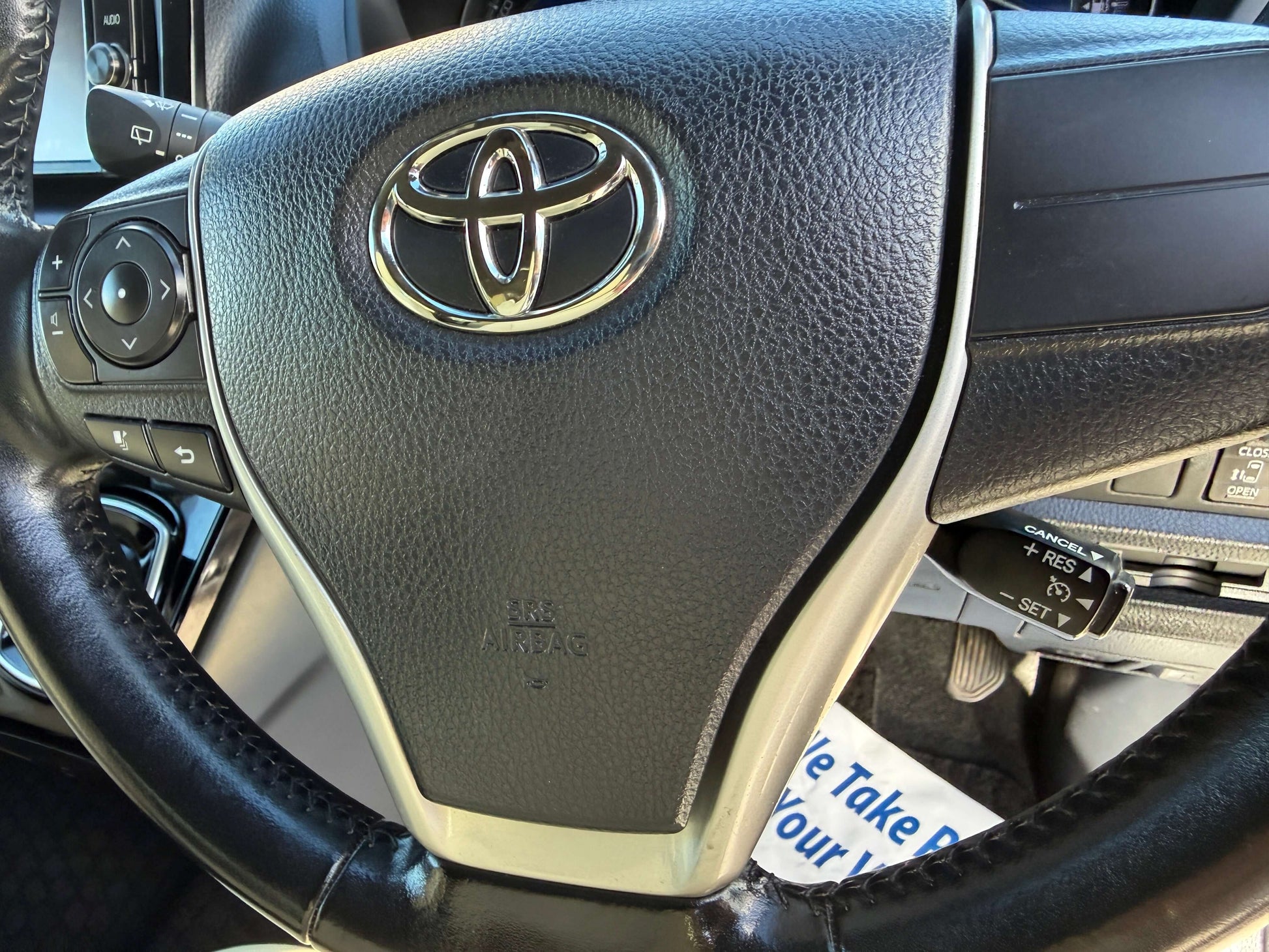 Close-up of the steering wheel featuring the Toyota logo in a 2017 Toyota Noah 1.8L Hybrid.