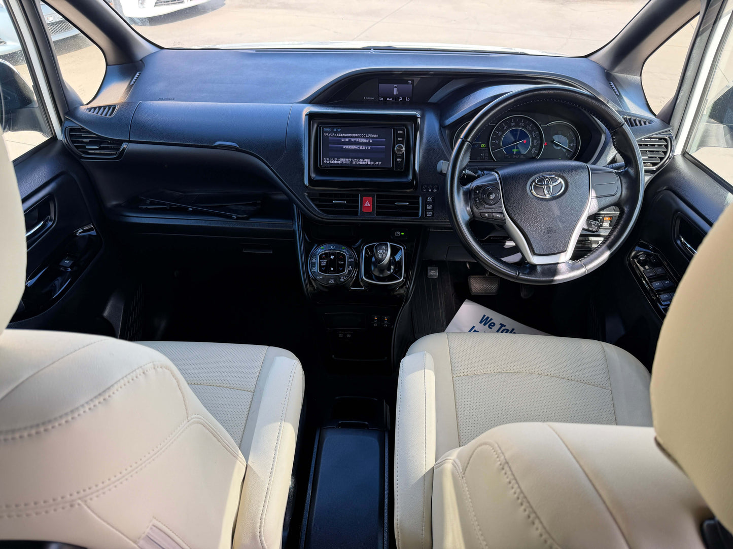 Interior view of a 2017 Toyota Noah 1.8L Hybrid with modern dashboard and beige leather seats.