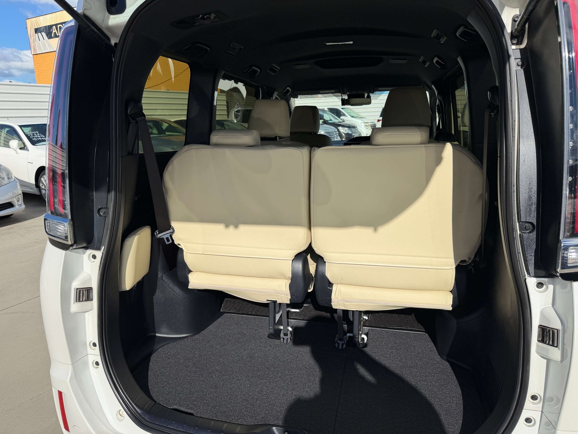 Interior view of the 2017 Toyota Noah 1.8L Hybrid showcasing spacious 7-seater configuration with beige seats.