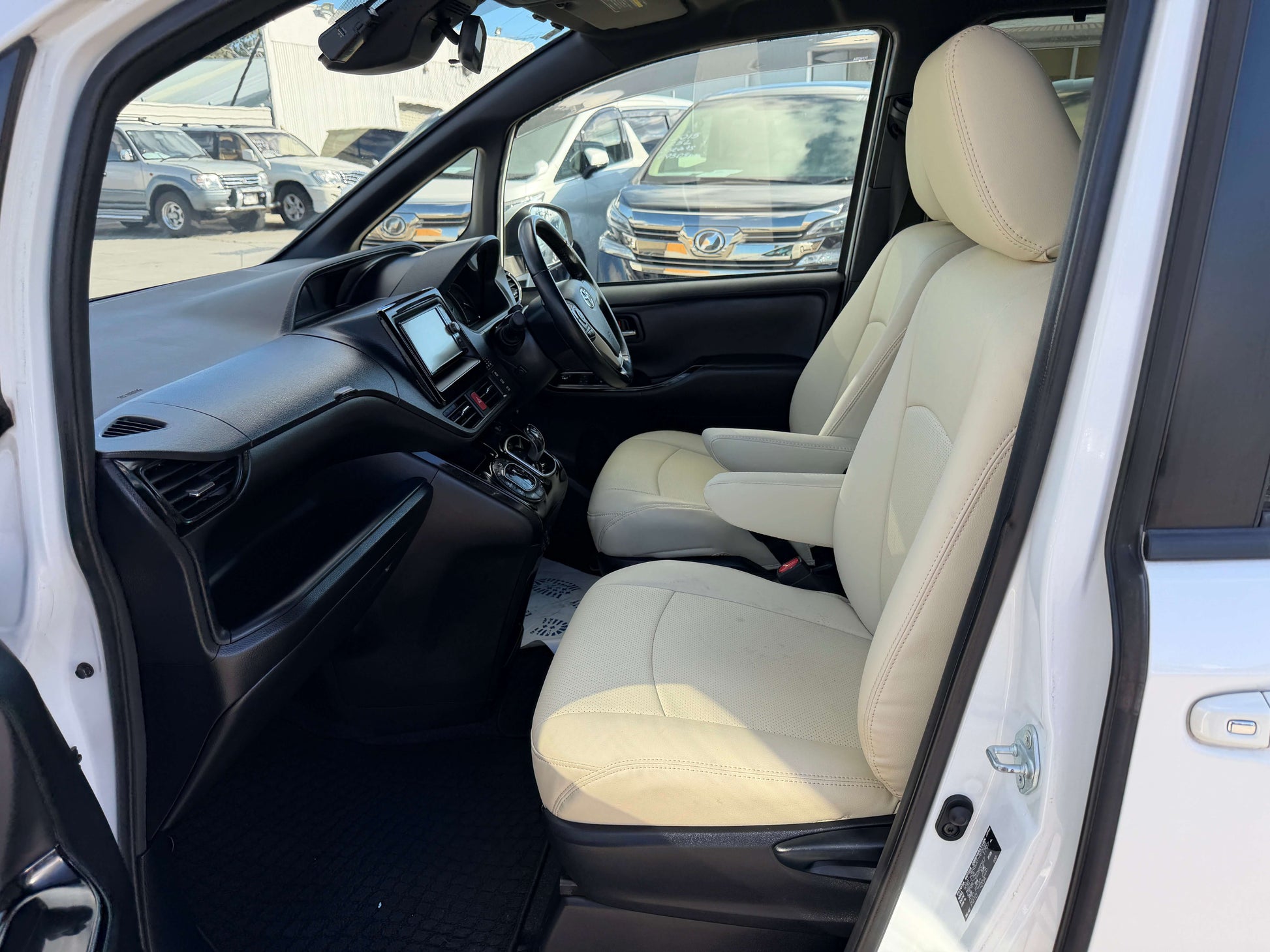 Interior view of a 2017 Toyota Noah 1.8L Hybrid G Premium Edition with beige seats and dashboard.