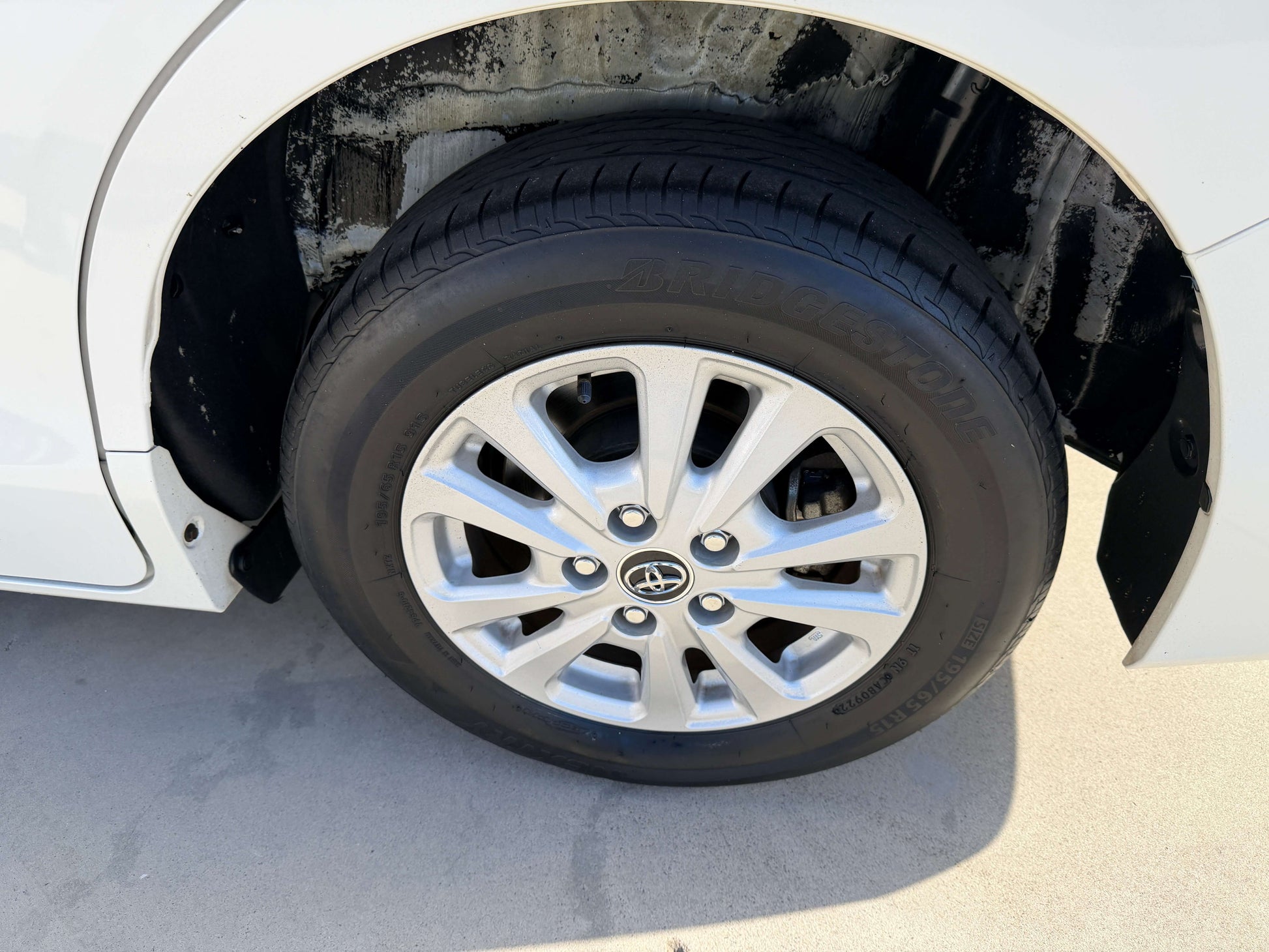 2017 Toyota Noah 1.8L Hybrid wheel and tire close-up on a white vehicle.