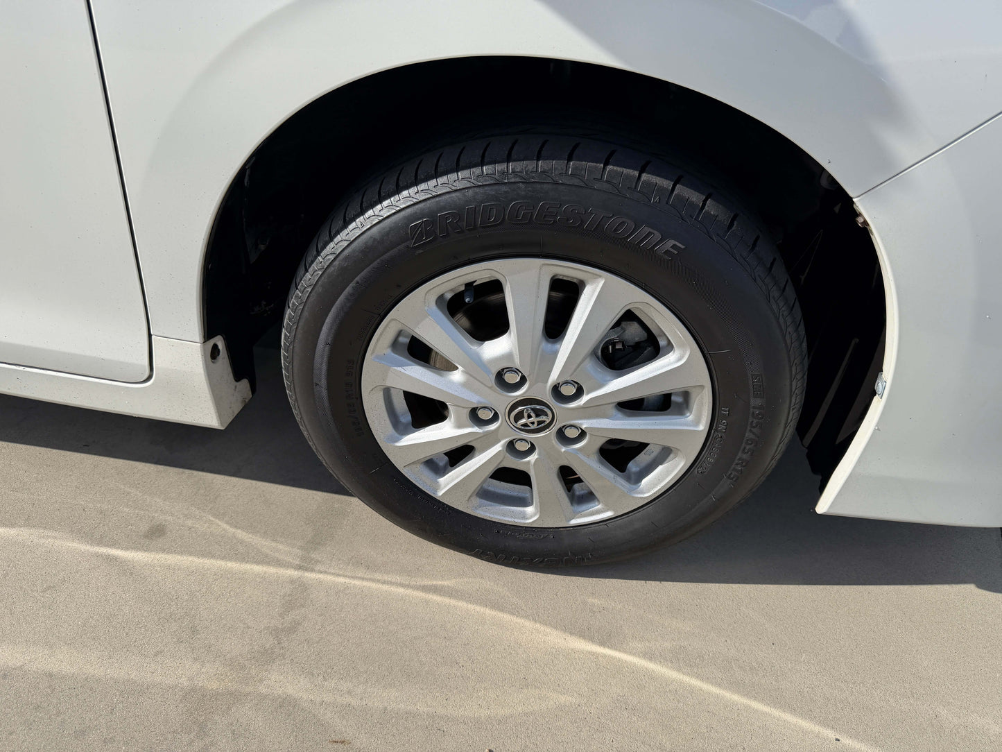 Close-up of the wheel of a 2017 Toyota Noah 1.8L Hybrid, featuring Bridgestone tires and stylish alloy rims.
