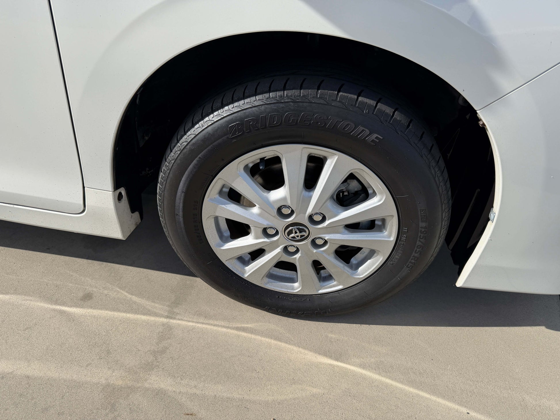 Close-up of the wheel of a 2017 Toyota Noah 1.8L Hybrid, featuring Bridgestone tires and stylish alloy rims.