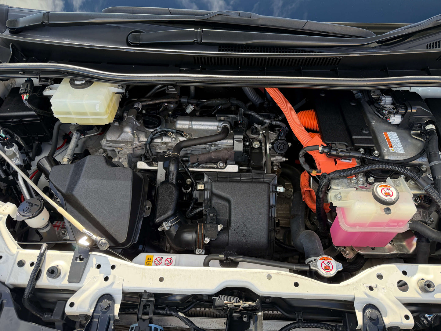 Engine compartment of a 2017 Toyota Noah 1.8L Hybrid showcasing components and design.