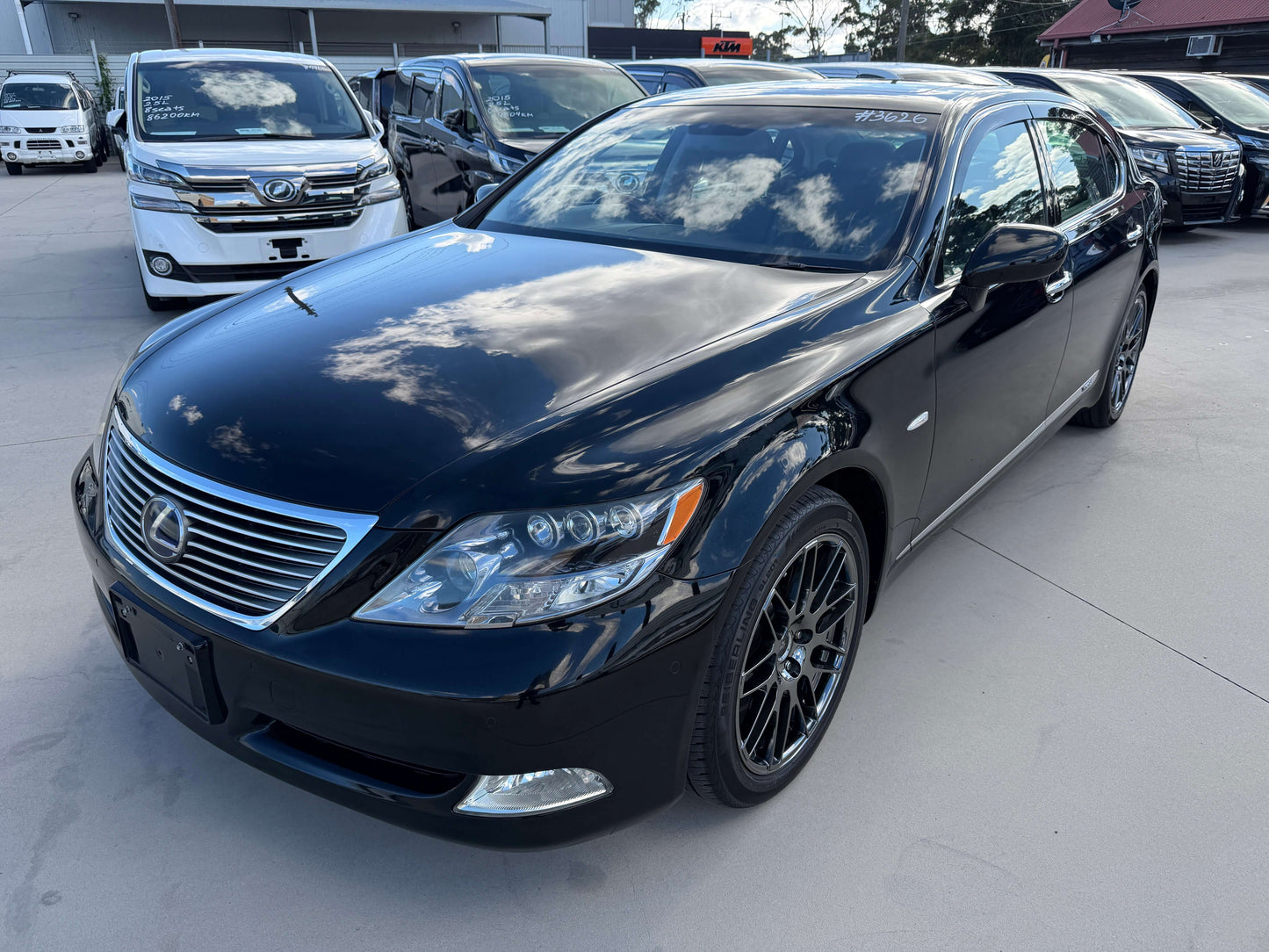 2007 Lexus LS600hL AWD V8 5.0L Hybrid luxury sedan in black parked outside, showcasing sleek design and stylish alloy wheels.