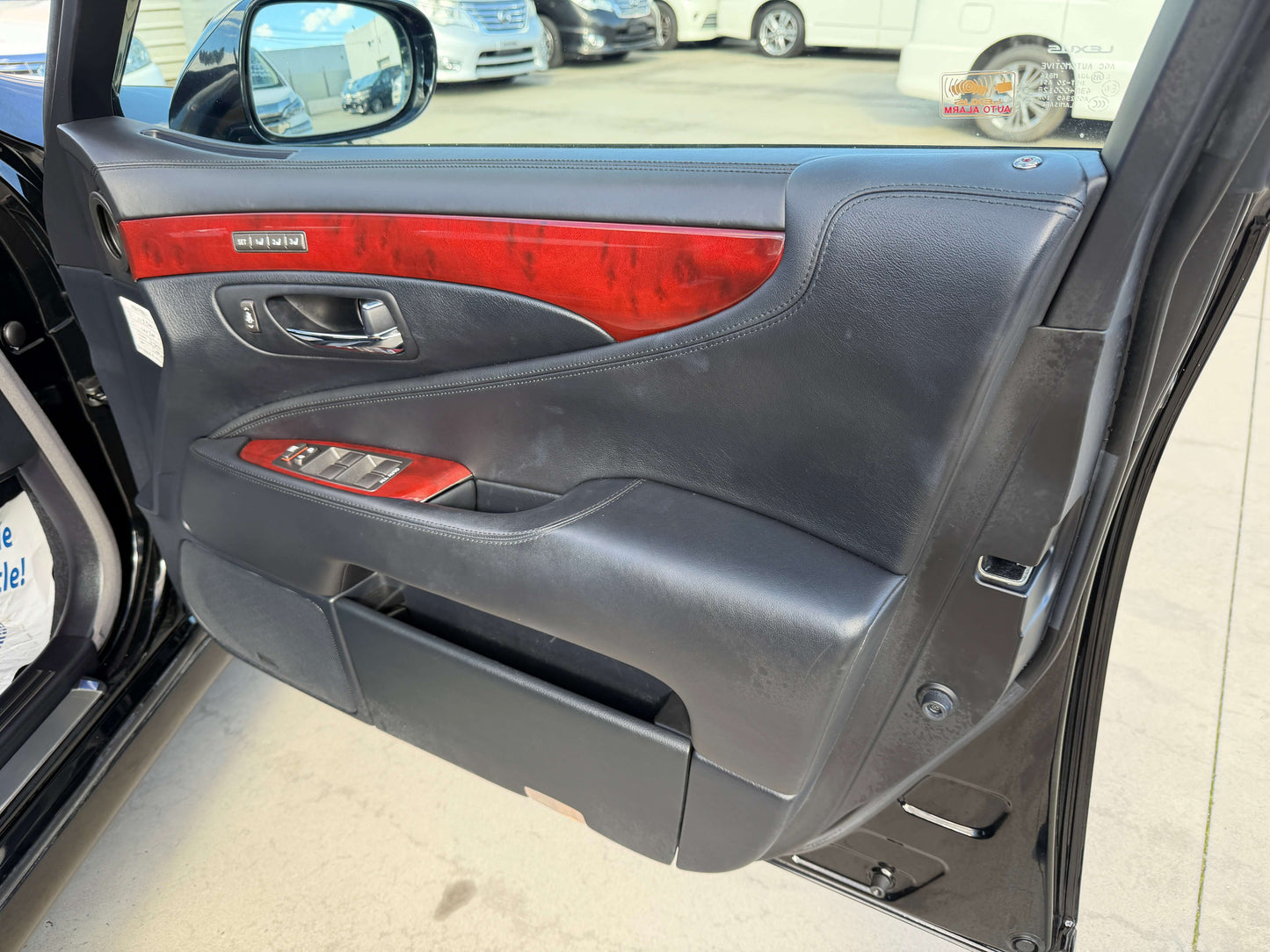 Interior view of the 2007 Lexus LS600hL AWD V8 5.0L Hybrid door panel featuring luxurious materials and controls.