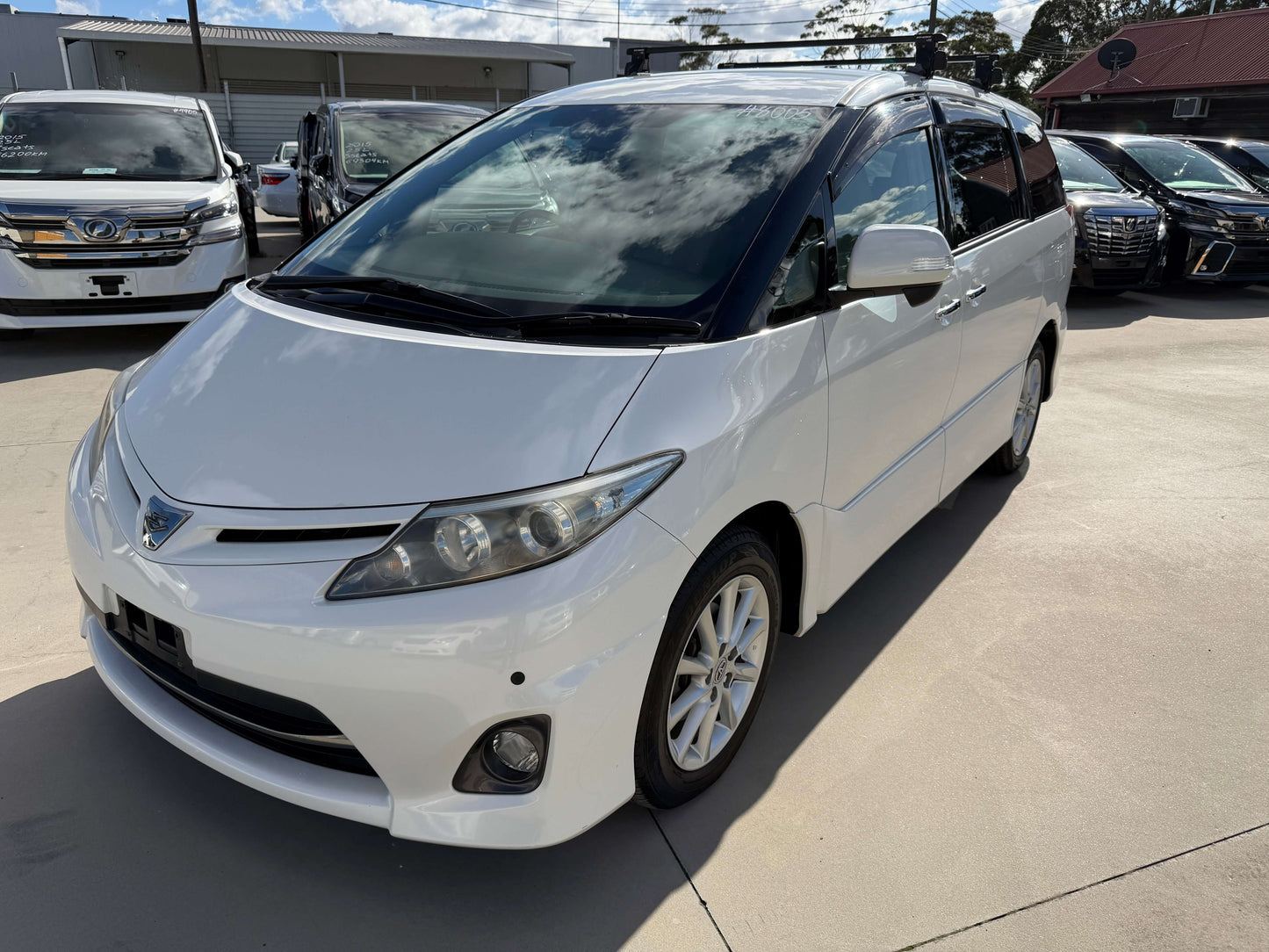 2010 Toyota Estima 2.4L 4WD Aeras G Edition white minivan parked outdoors with clear sky.