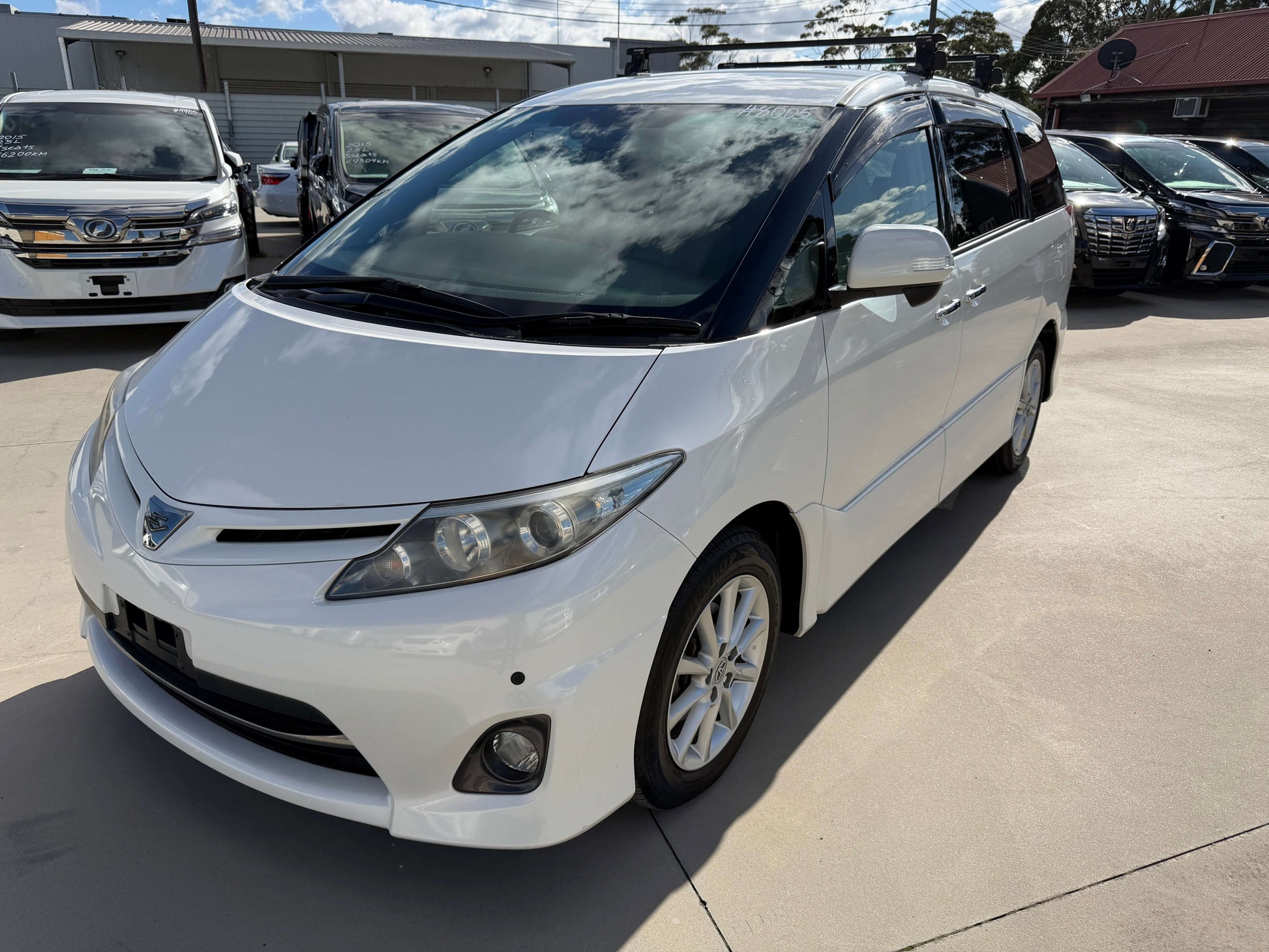 2010 Toyota Estima 2.4L 4WD Aeras G Edition white minivan parked outdoors with clear sky.