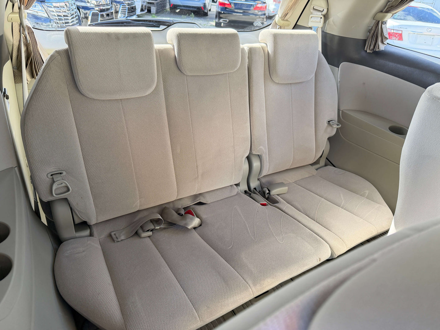 Interior view of the rear seating area in a 2010 Toyota Estima 2.4L 4WD Aeras G Edition, showing three seats.