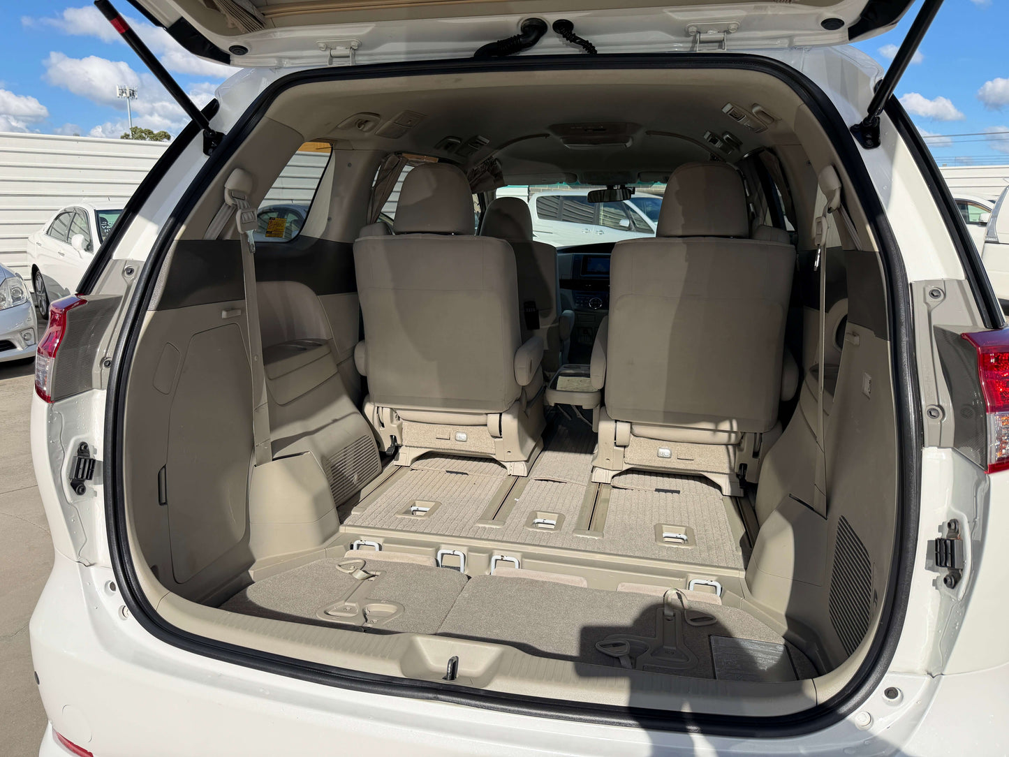 Interior view of the rear cargo space of a 2010 Toyota Estima 2.4L 4WD, showcasing seating and storage features.