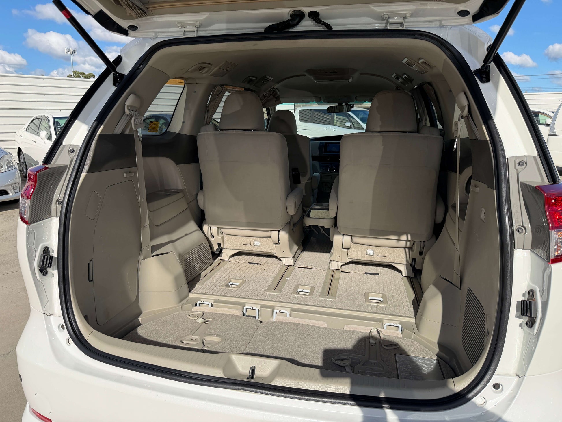Interior view of the rear cargo space of a 2010 Toyota Estima 2.4L 4WD, showcasing seating and storage features.