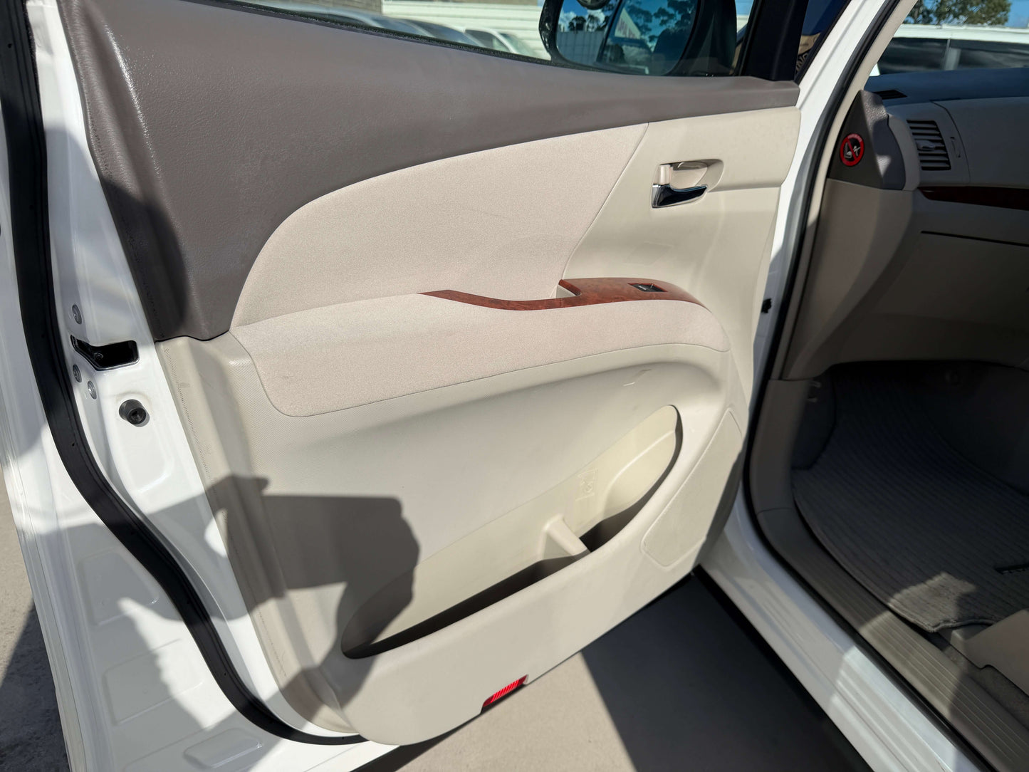 Interior door panel of 2010 Toyota Estima 2.4L 4WD showing beige upholstery and wood accents.