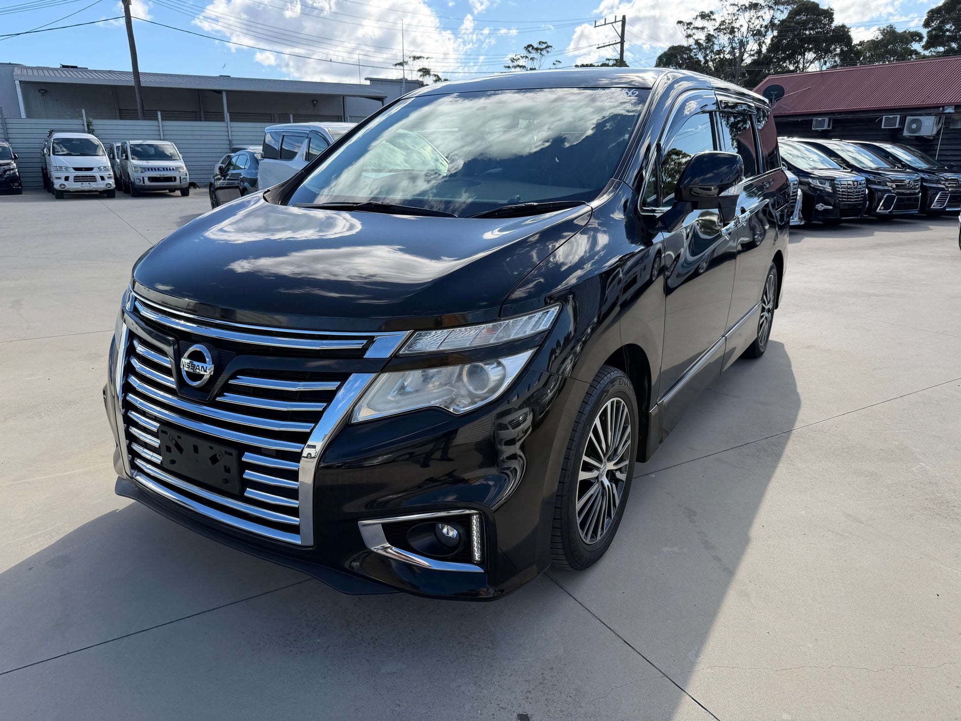 2015 Nissan Elgrand 2.5L 250 Highway Star luxury people mover in black, showcased in a parking lot.