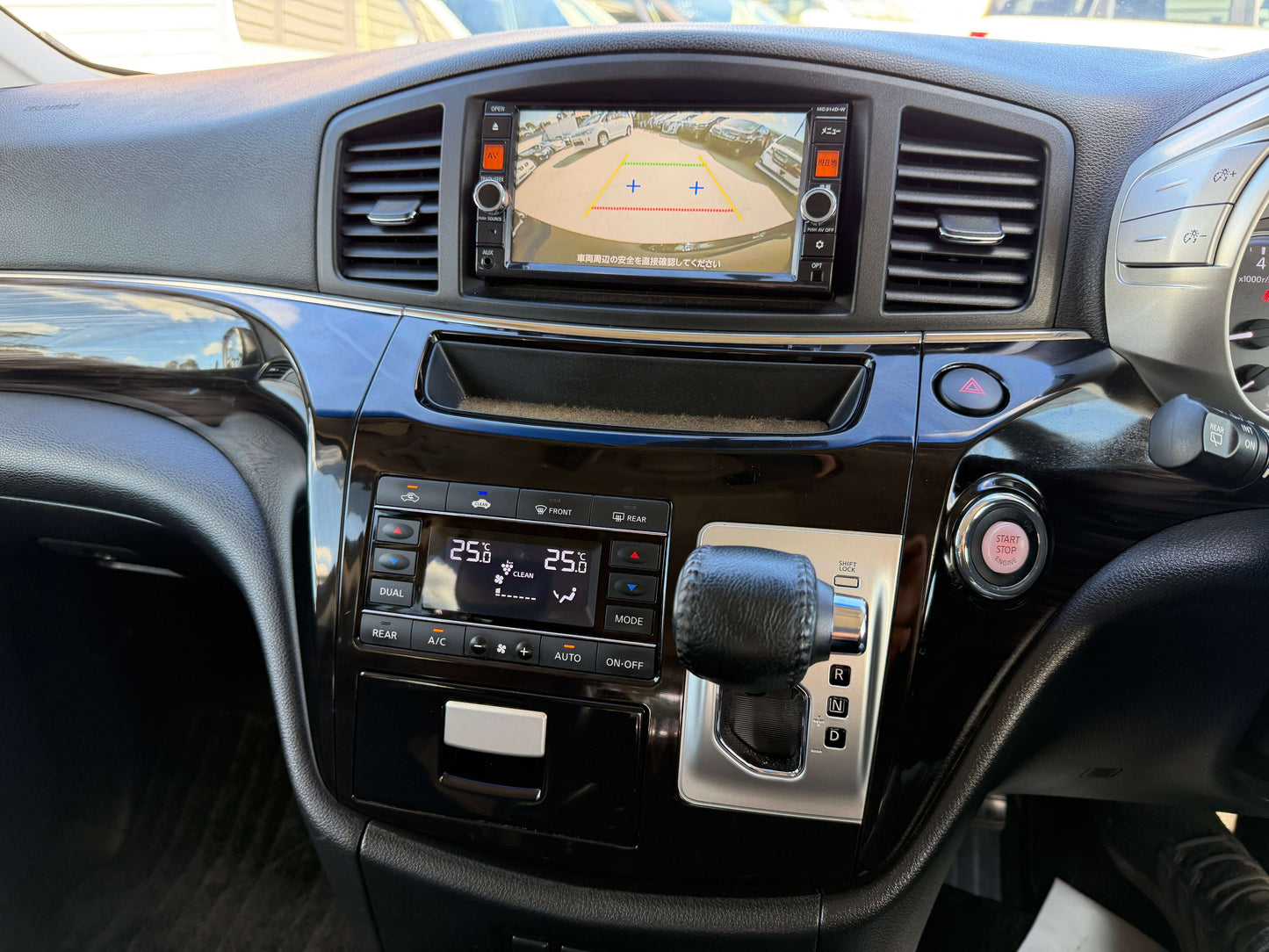 Interior view of a 2015 Nissan Elgrand 2.5L 250 Highway Star with dashboard, controls, and navigation screen.
