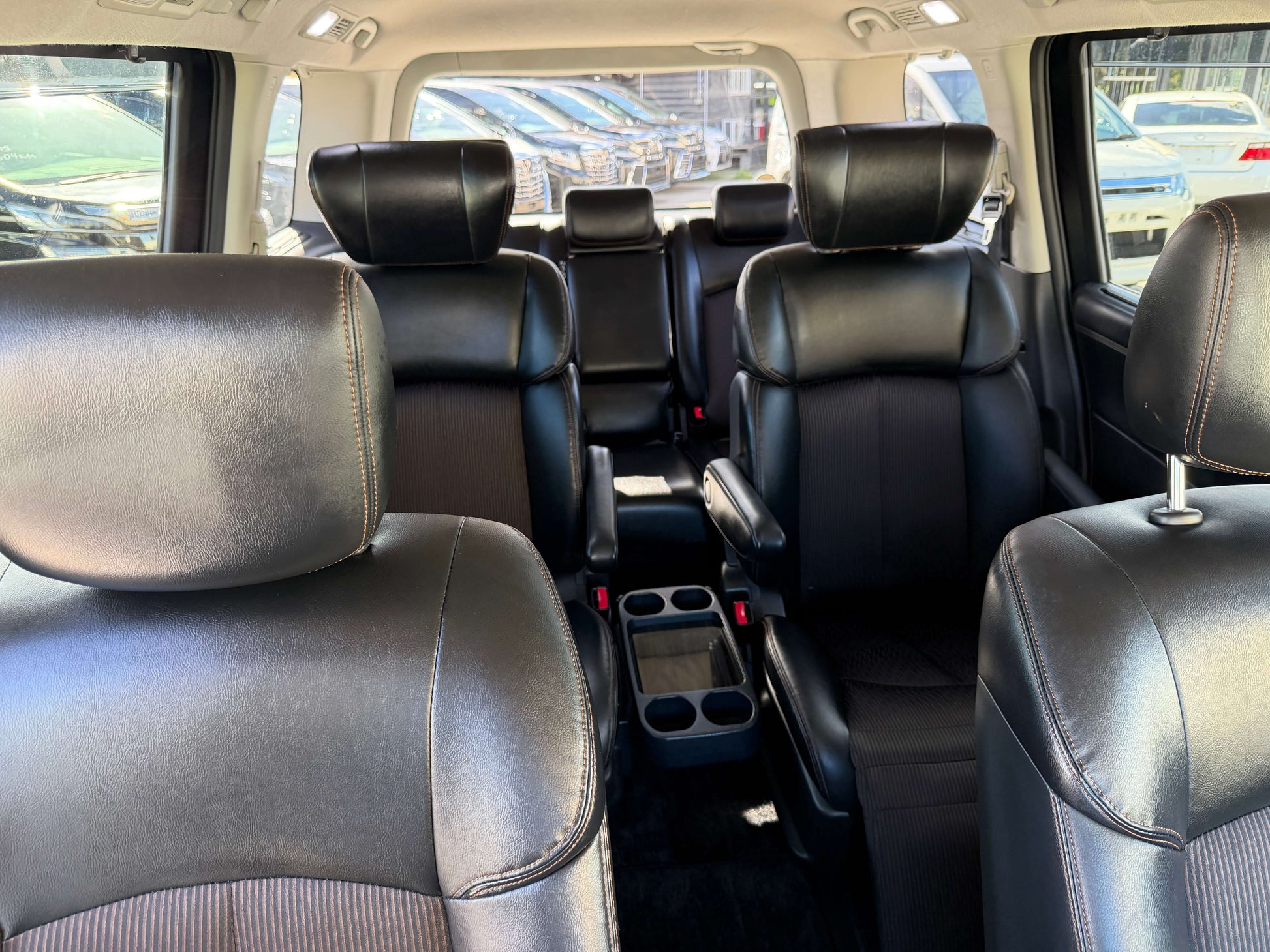 Interior view of 2015 Nissan Elgrand 2.5L 250 Highway Star, showcasing spacious black leather seating for 7 passengers.