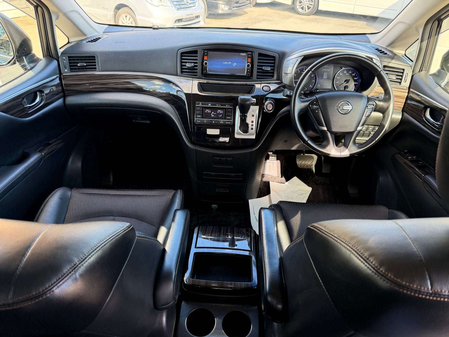 Interior view of 2015 Nissan Elgrand 2.5L 250 Highway Star seating with luxury finishes and control panel.
