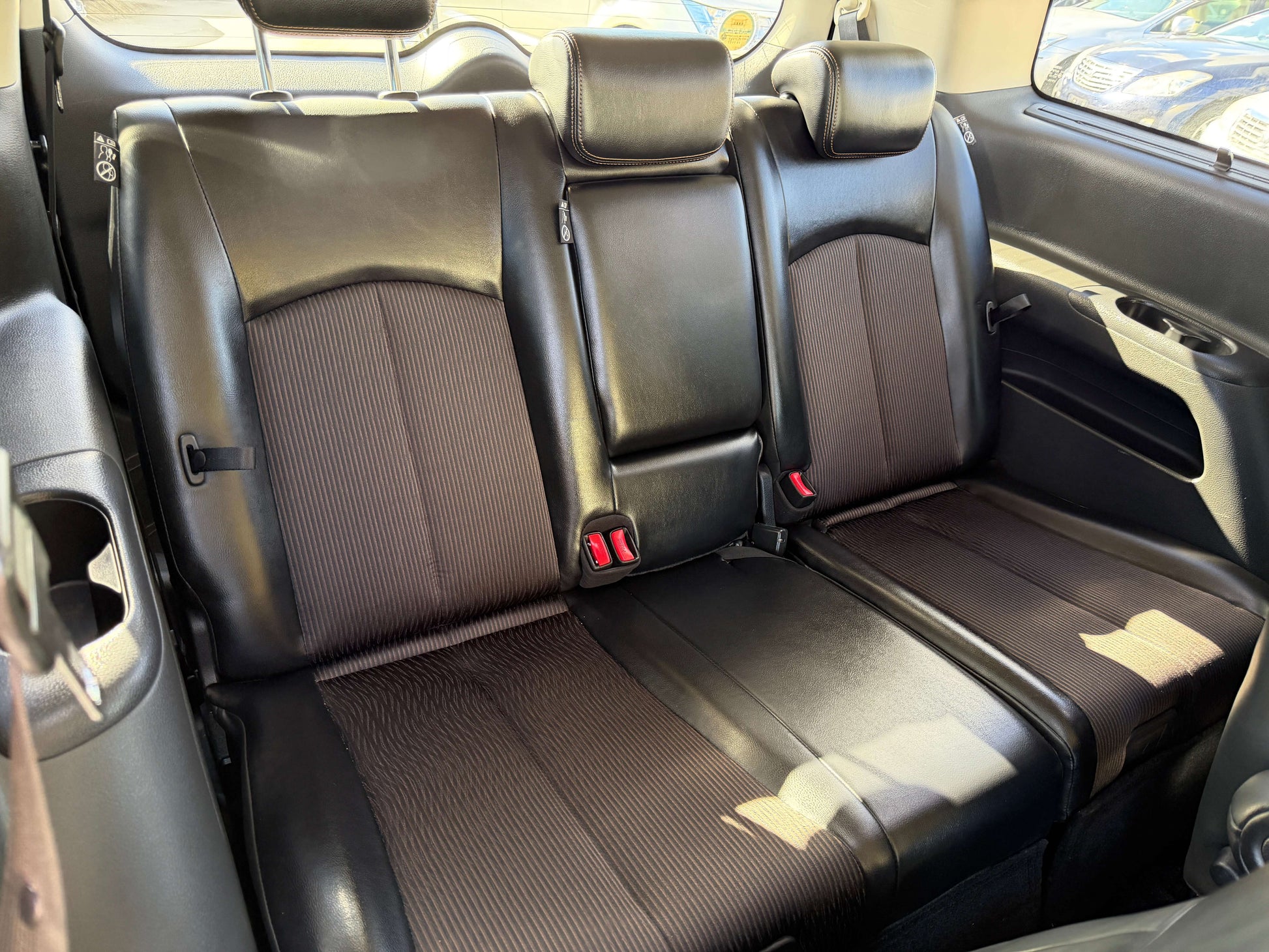 Interior seating of a 2015 Nissan Elgrand 2.5L 250 Highway Star with black leather upholstery, designed for comfort.