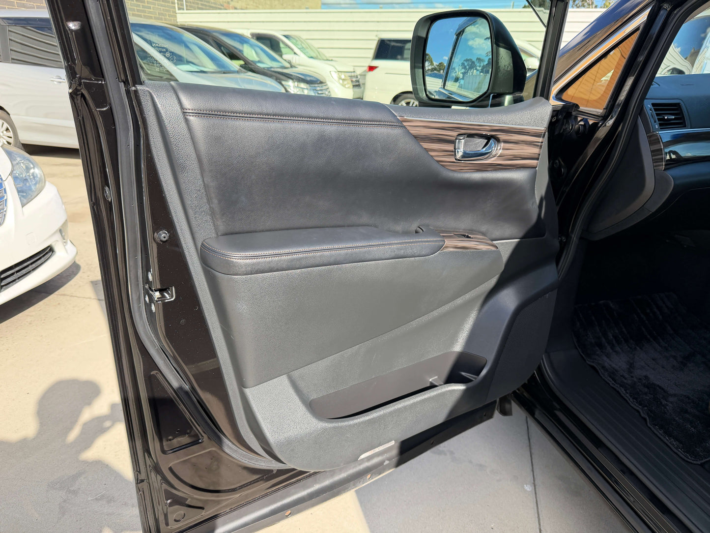 Interior view of 2015 Nissan Elgrand 2.5L showing the driver's side door panel and handle.