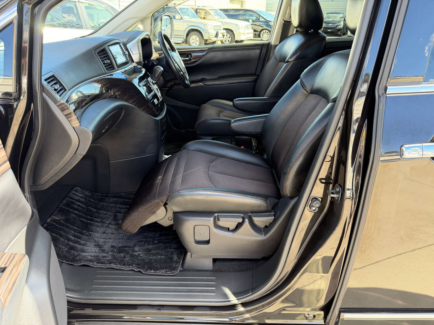 Interior view of 2015 Nissan Elgrand 2.5L 250 Highway Star with luxury black leather seats and spacious cabin.