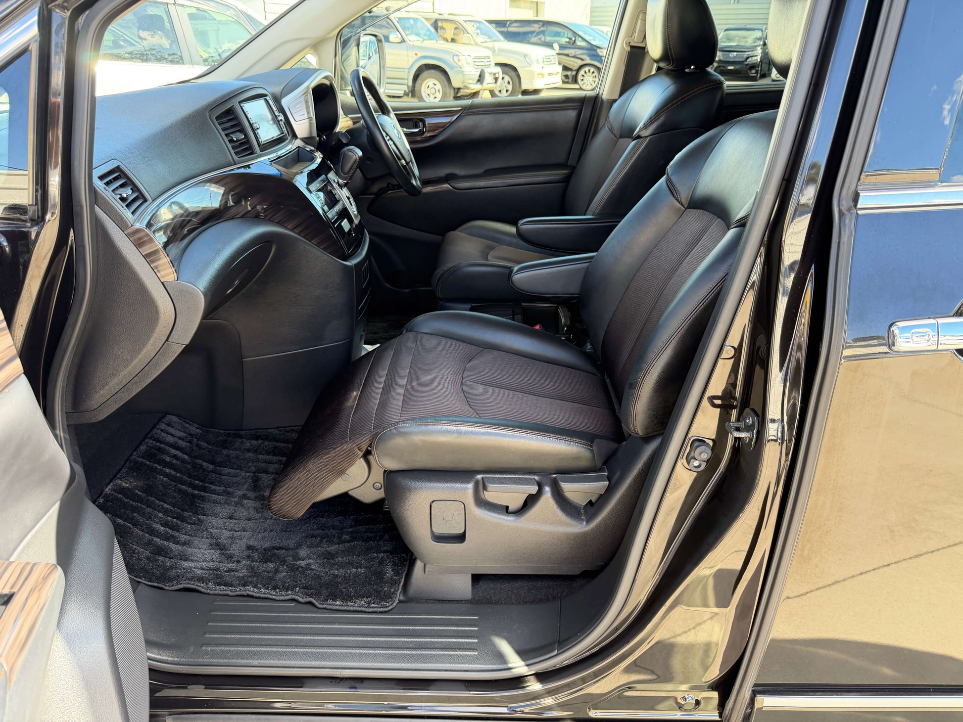 Interior view of 2015 Nissan Elgrand 2.5L 250 Highway Star with luxury black leather seats and spacious cabin.