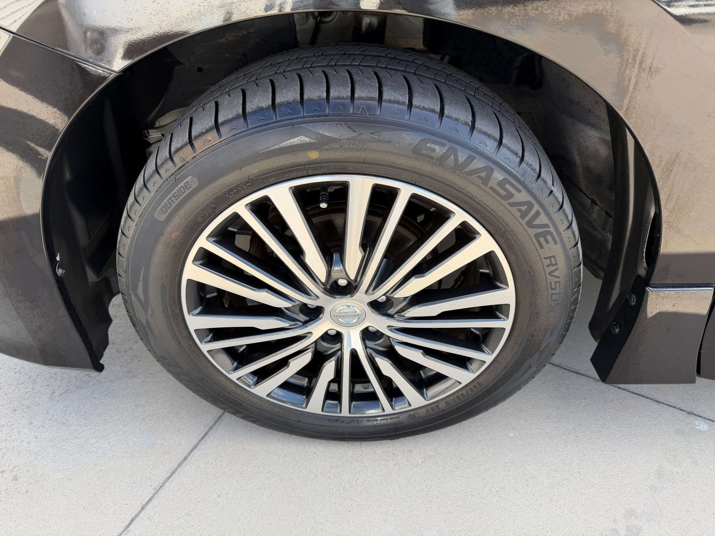 2015 Nissan Elgrand 2.5L alloy wheel and tire close-up, showcasing stylish design and quality for a premium people mover.