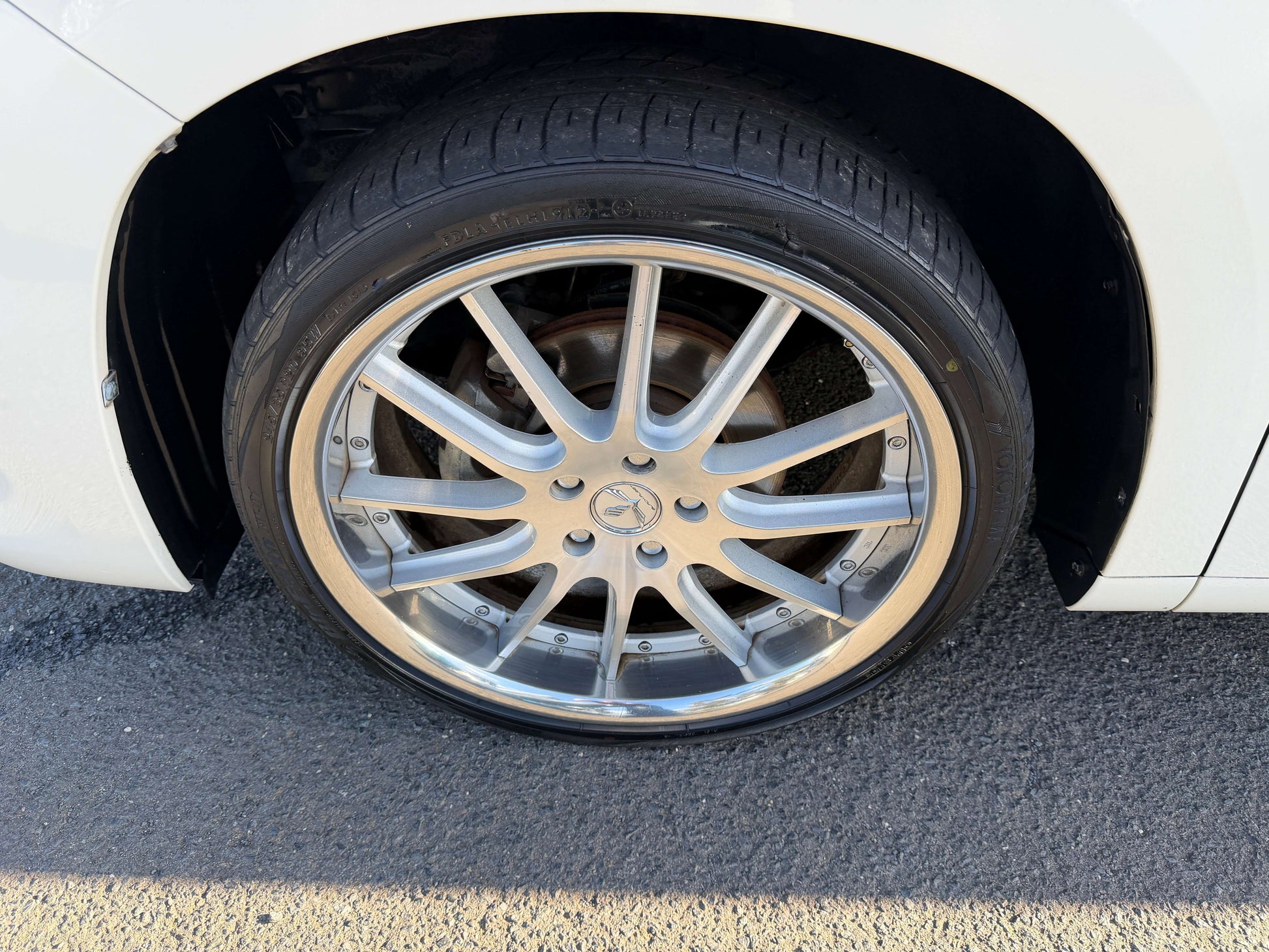 2009 Toyota Alphard 2.4L Close-up of a stylish silver alloy wheel on a white car, showcasing the tire and rim design.