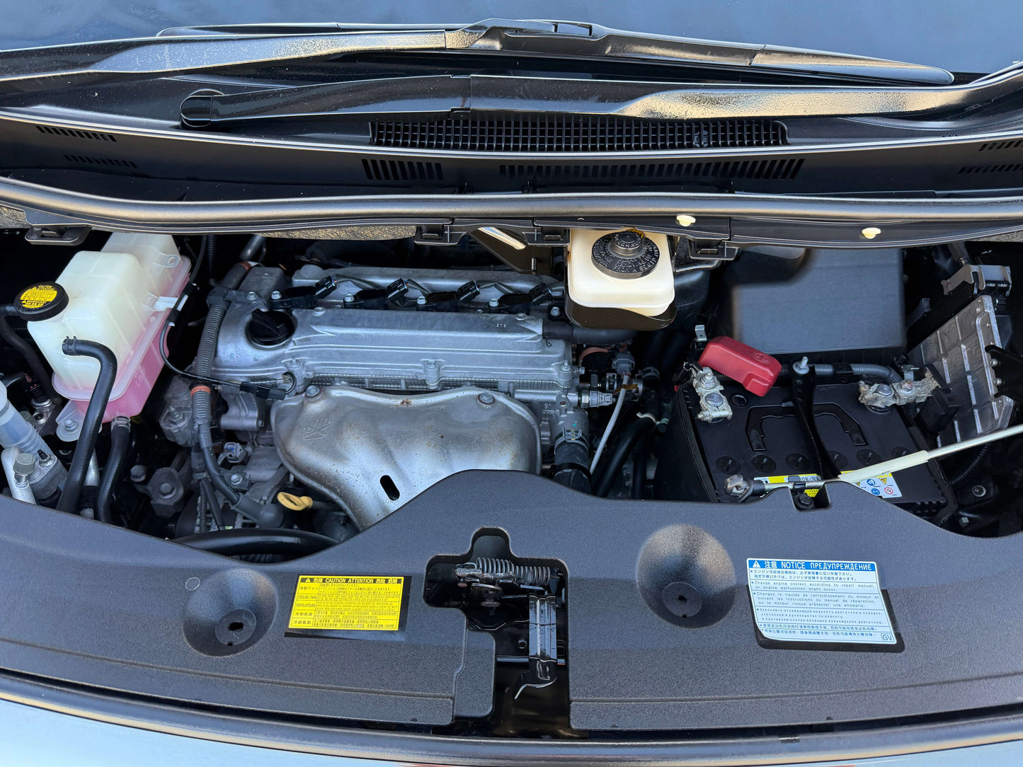Engine compartment of a 2014 Toyota Vellfire 2.4L, showcasing key components and features.