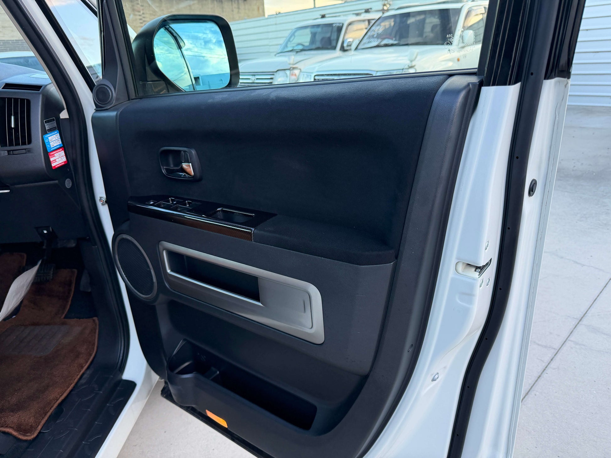 Interior view of the driver door panel of a 2017 Mitsubishi Delica D5 2.3 Diesel-Turbo 4WD with control buttons.