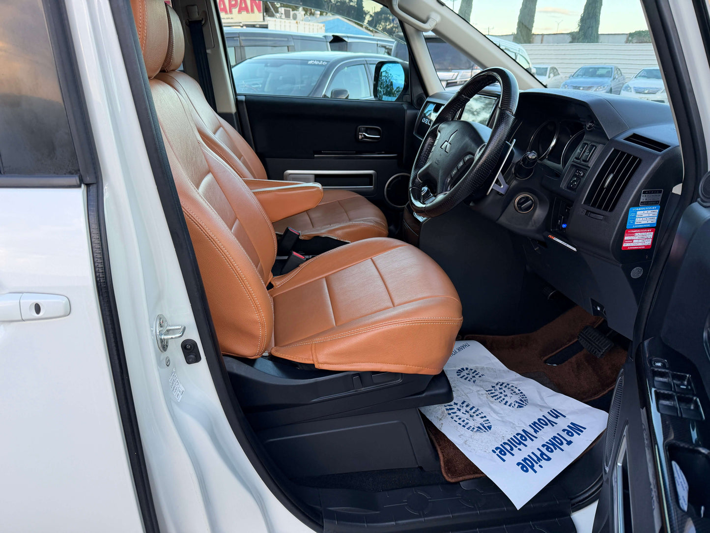 Interior view of the 2017 Mitsubishi Delica D5 2.3 Diesel-Turbo 4WD with brown leather seats and dashboard.